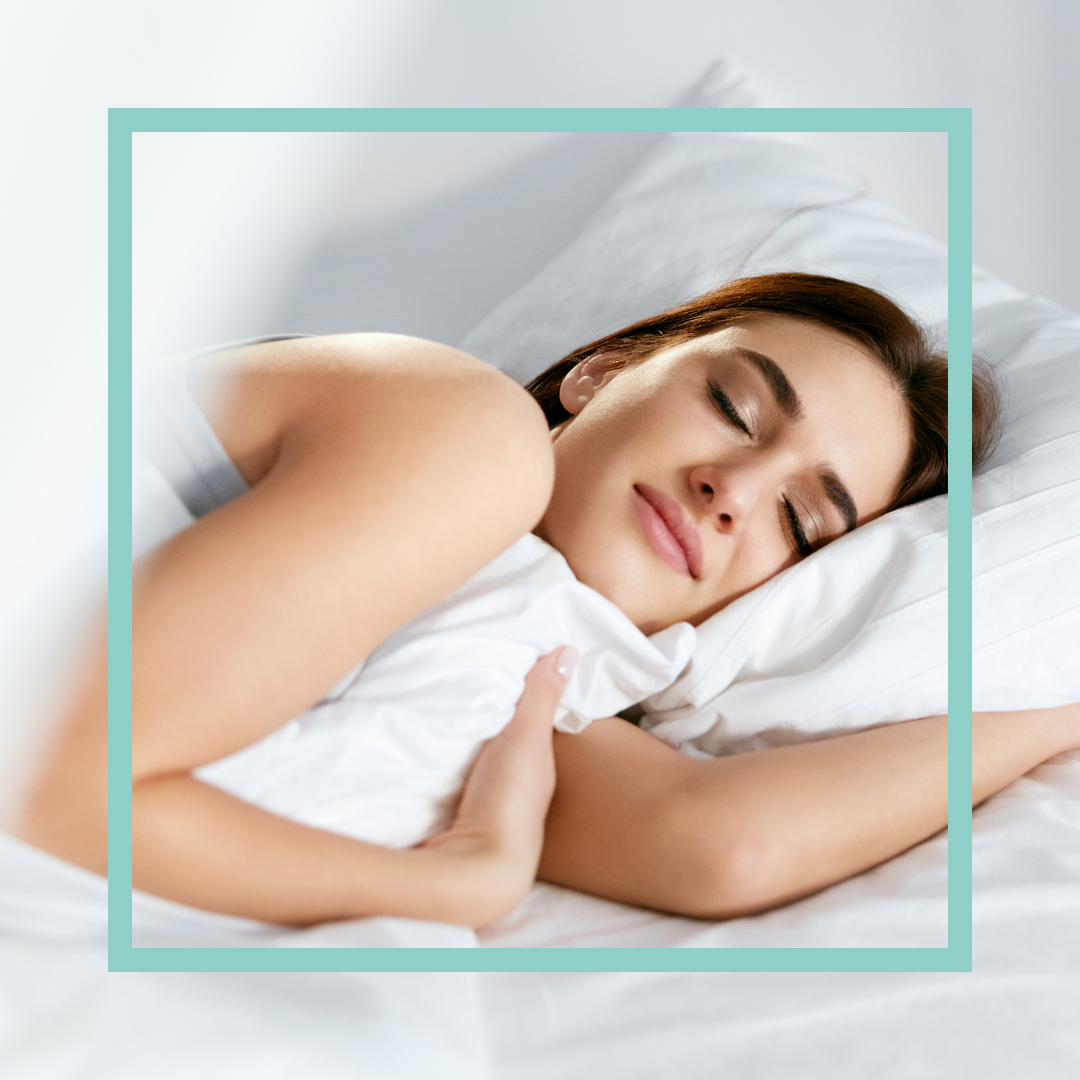 Woman sleeping comfortably in a bright bed as part of a healthy sleep routine