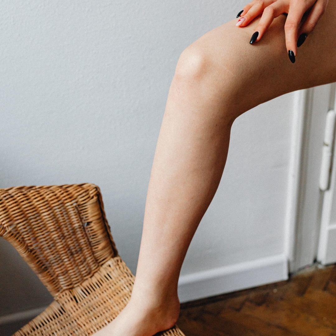 Smooth bare leg after waxing with a hand resting near the knee