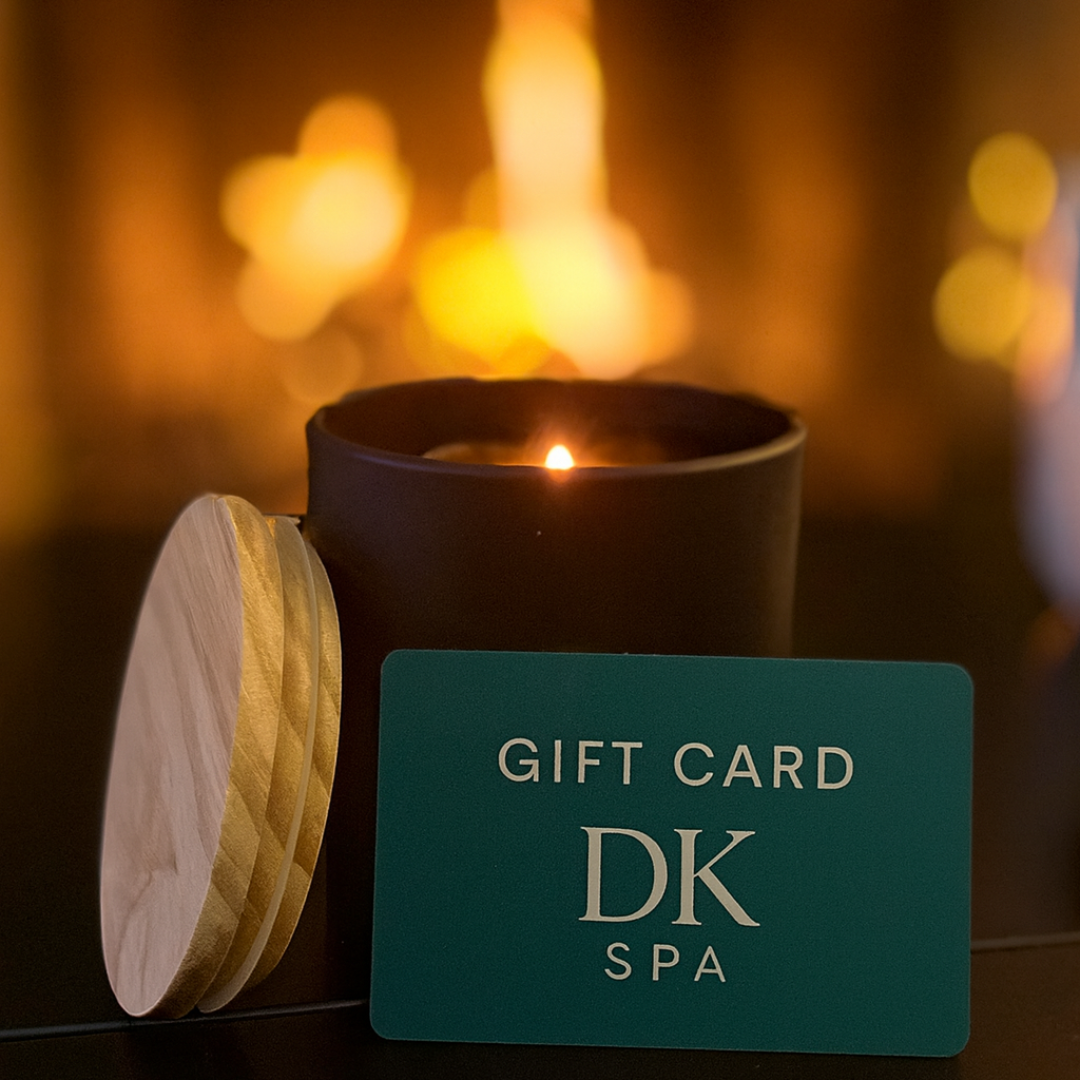 DK Spa gift card displayed beside a candle with warm ambient lighting in the background.