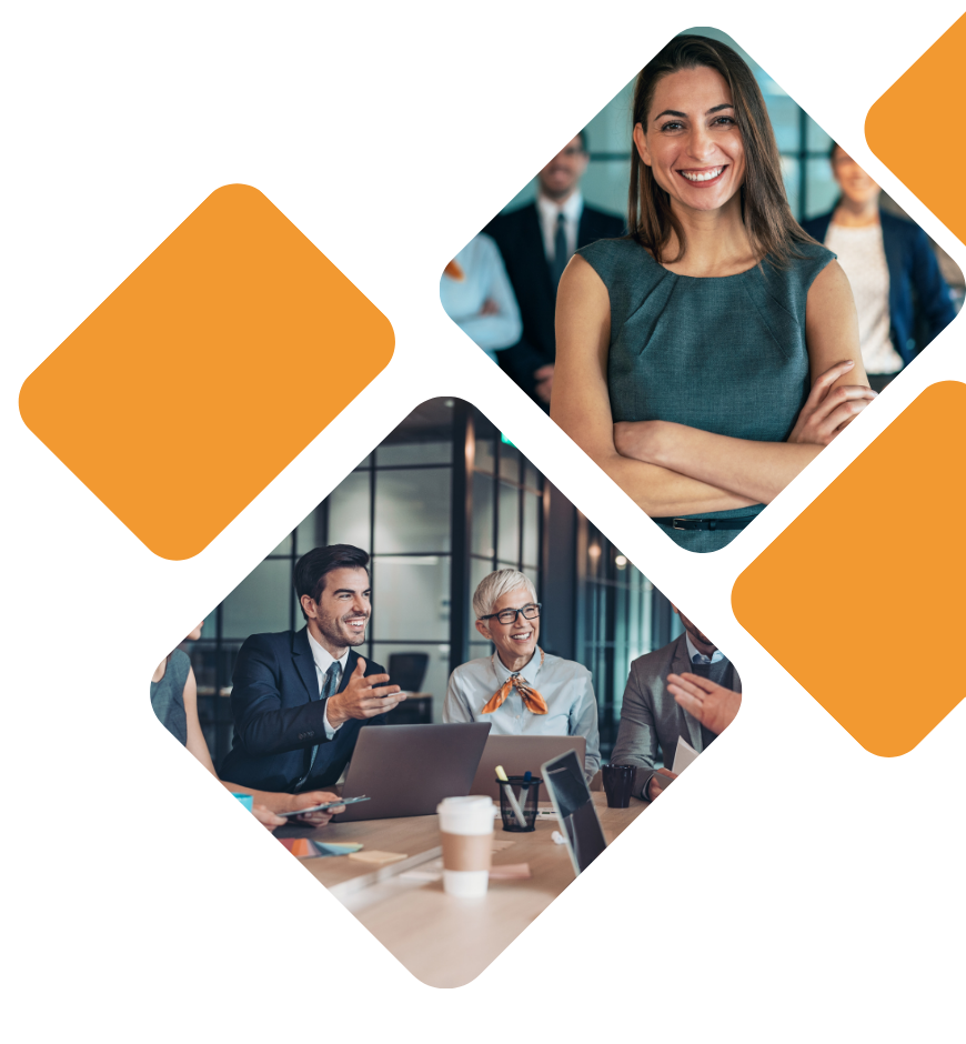 Businesswomen and men in a meeting room, smiling and engaging in discussion, with laptops and coffee cups on the table.