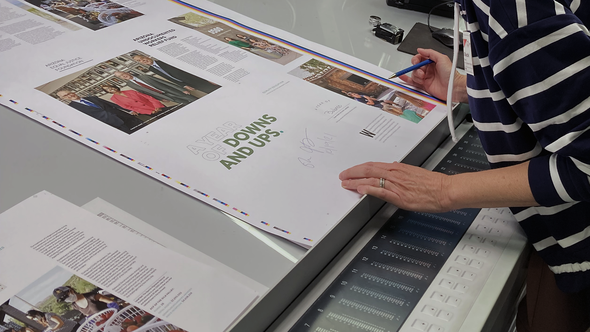 12below press check for a client; standing at the press reviewing a press sheet for an annual impact report