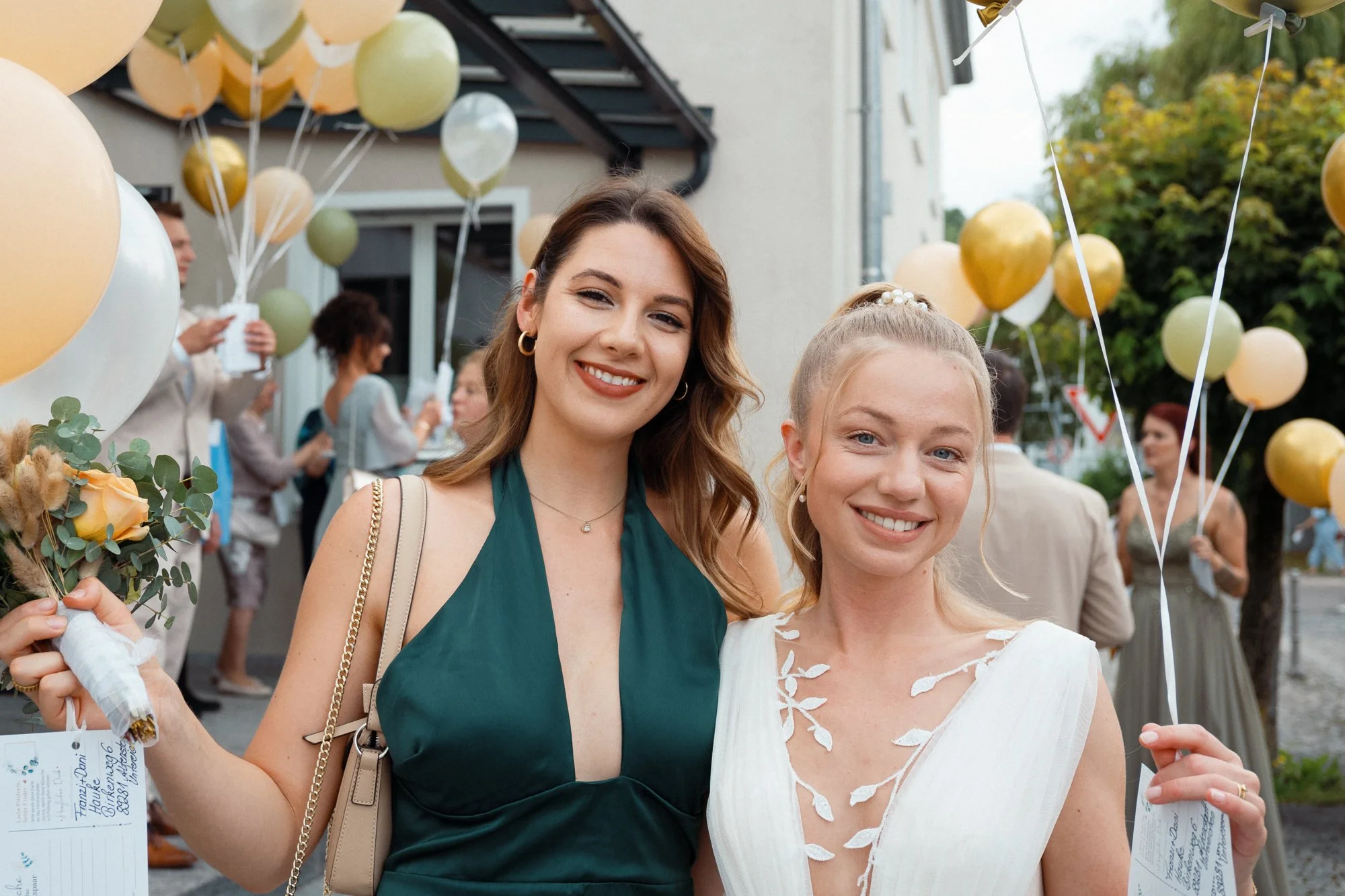 Zwei Frauen bei einer Feier, umgeben von bunten Ballons, die Freude und festliche Atmosphäre vermitteln.
