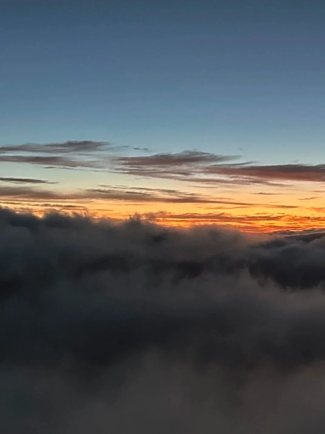 Sky during sunset with colorful clouds and mist or fog below.