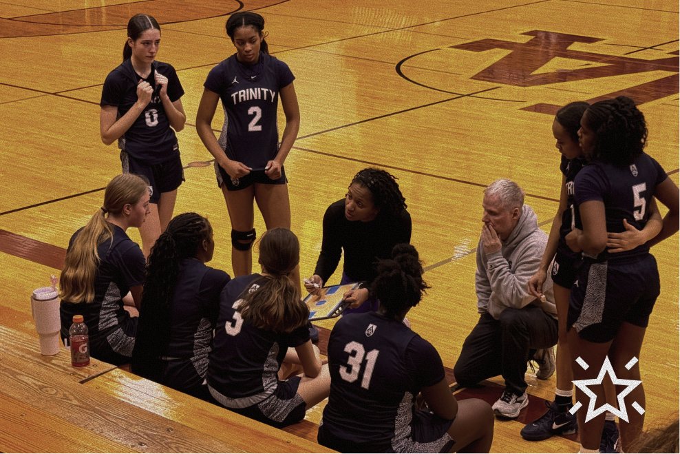 Basketball coach giving instructions to a team during a timeout in a gymnasium.