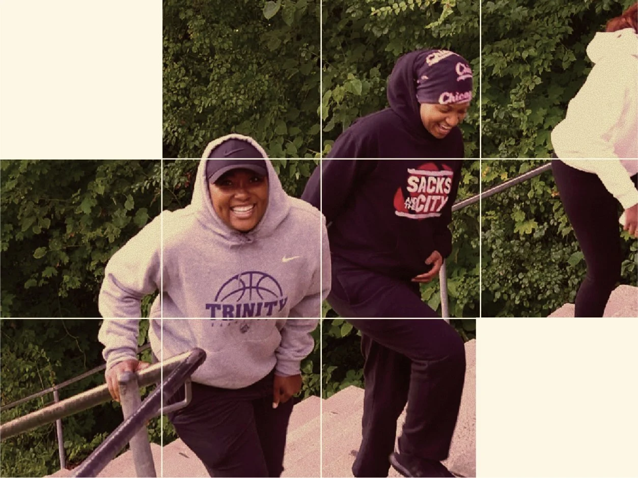 Two women in athletic clothing, smiling and laughing, climbing stairs outdoors near bushes.
