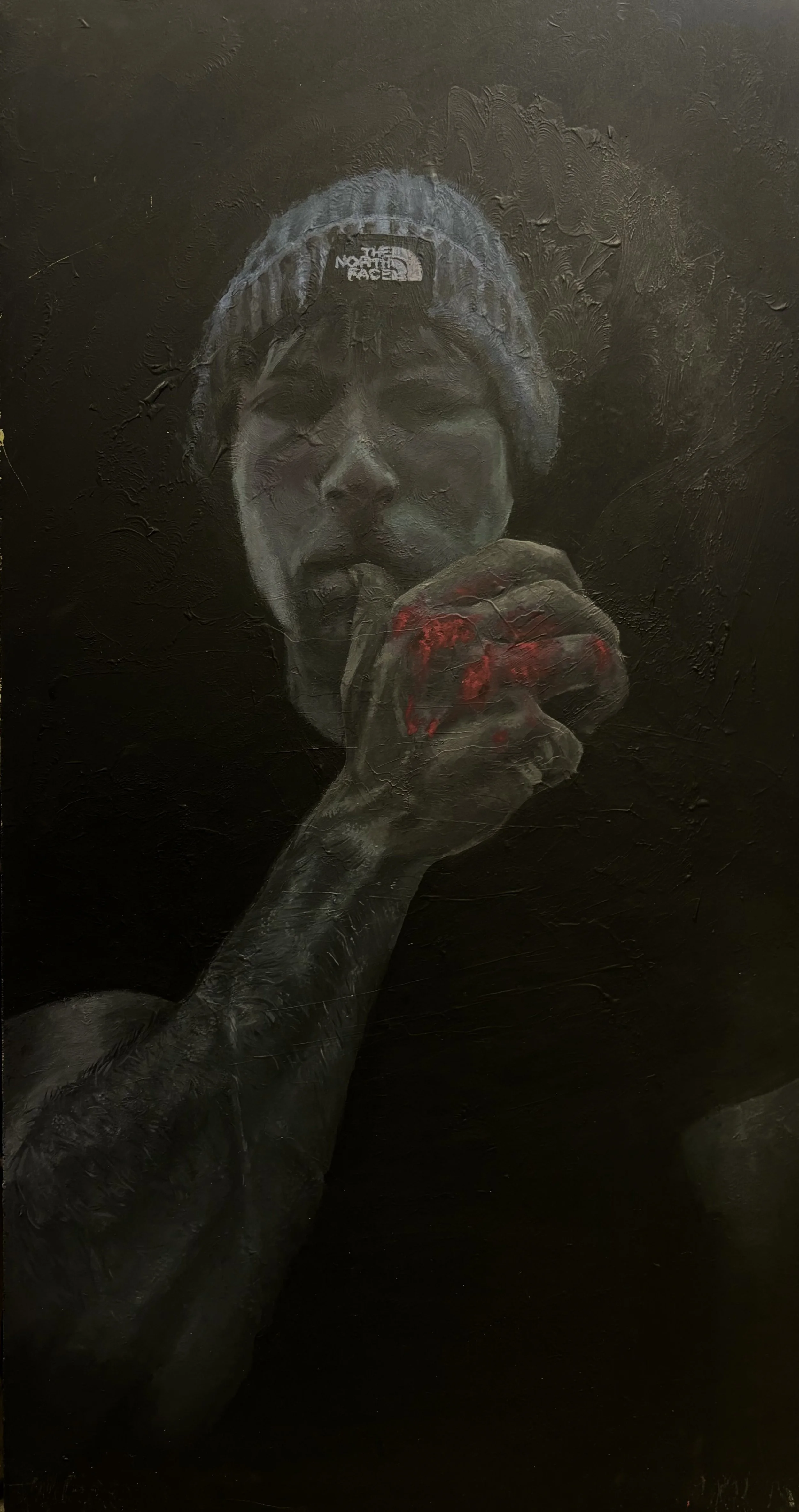 A monochrome painting of a person's face wearing a beanie, holding a red-tinted, partially visible object near their mouth, set against a dark background.