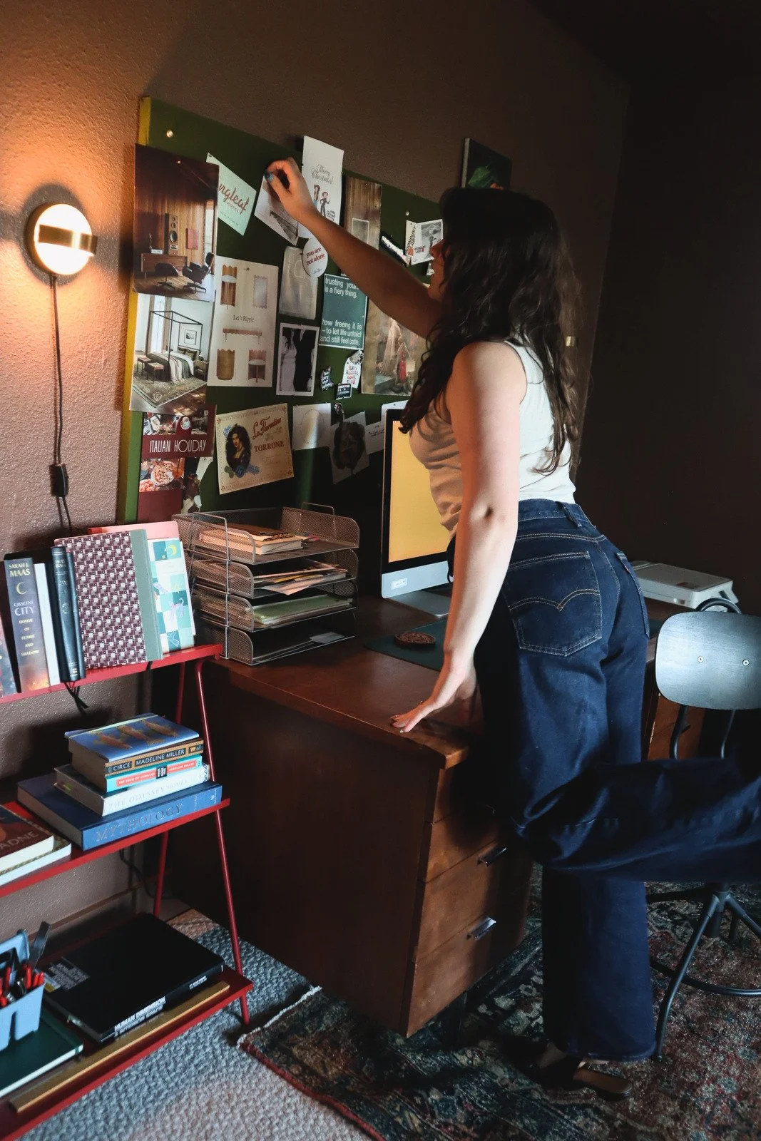 medium wide image of interior decorator adding paper to bulletin board