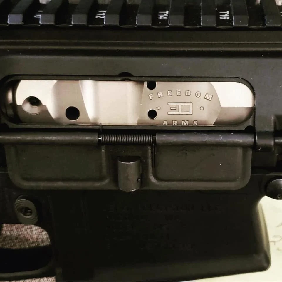 Close-up of a firearm's receiver with a marking that reads 'FREEDOM ARMS' and '30', showing part of a firearm mechanism.