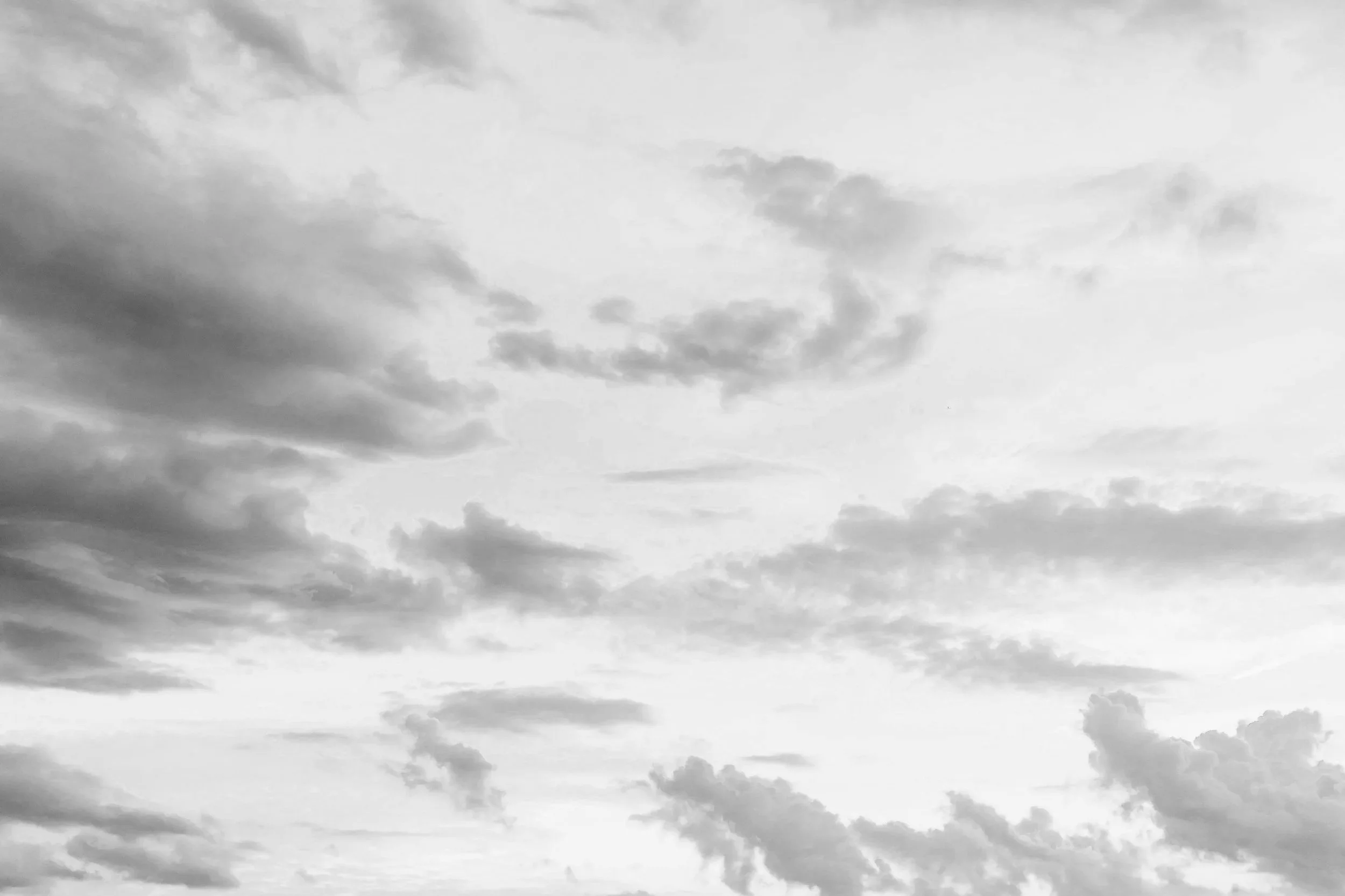 Black and white photo of a cloudy sky with various cloud formations.