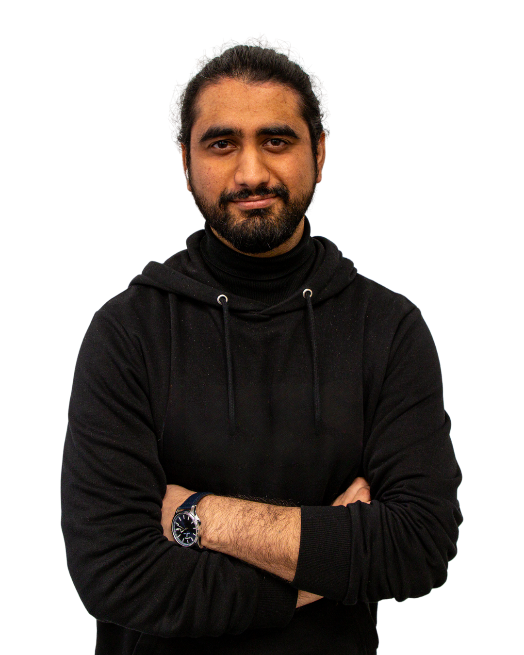 A man with a beard and long hair tied back, wearing a black hoodie and a wristwatch, standing with arms crossed and smiling slightly against a dark background.