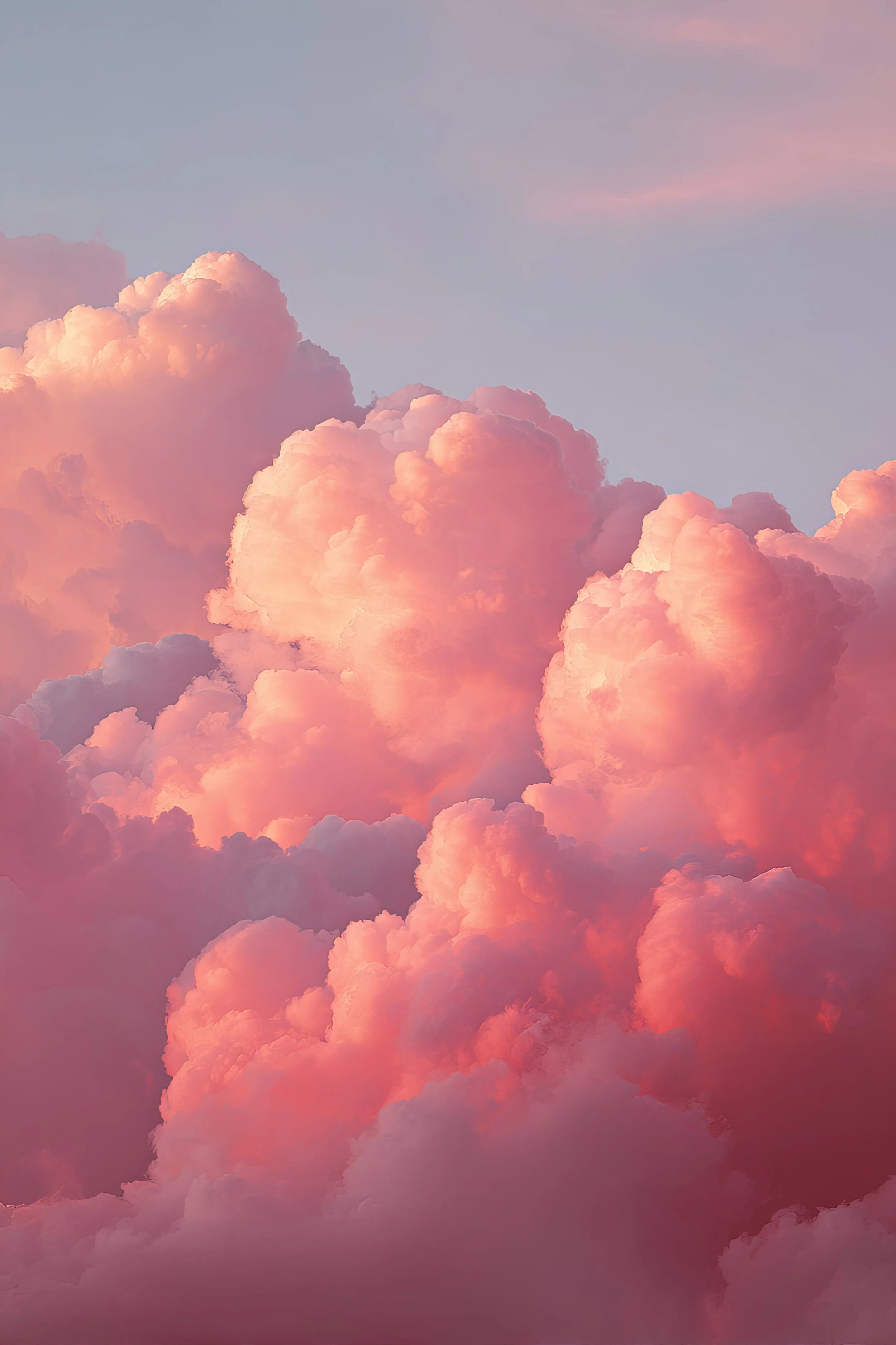 Pink and orange fluffy clouds in a blue sky during sunset or sunrise.