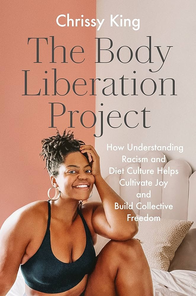 Book cover titled 'The Body Liberation Project' by Chrissy King, featuring a woman with dreadlocks and a black sports bra smiling on a bed with pillows.