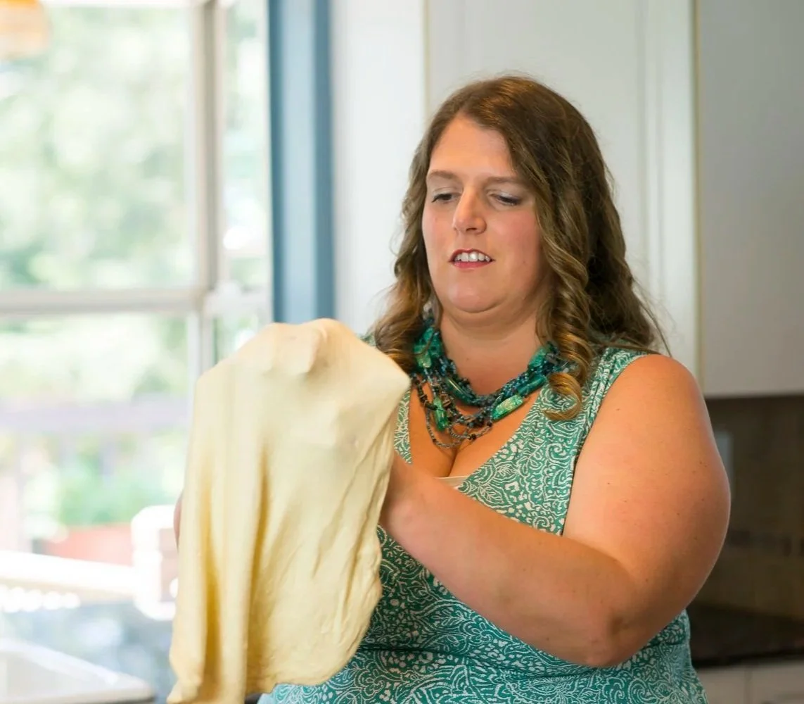 Woman stretching dough in a kitchen