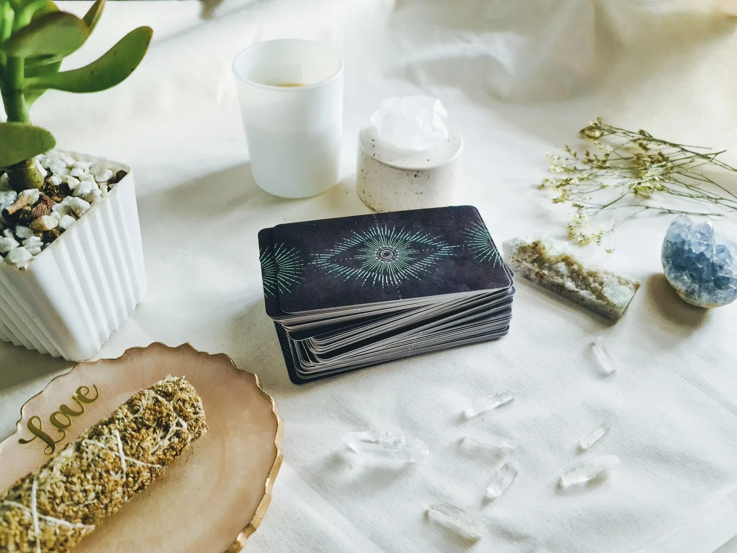 Tarot cards laid out on a table with a black candle and some coins or jewelry nearby.