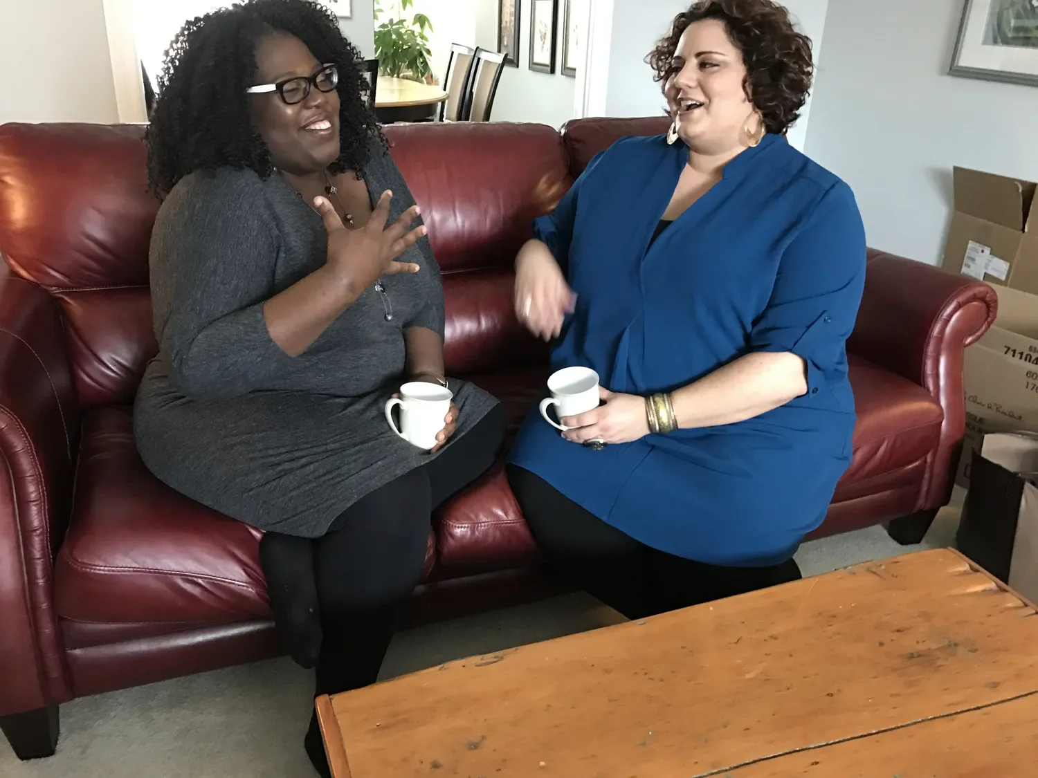 A vibrant gathering of diverse individuals filled with energy, sharing laughter and ideas in a sunlit room, celebrating body positivity and fat liberation amidst a cozy, inviting atmosphere.