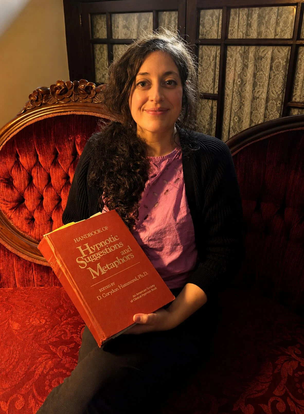 Hypnotherapy practitioner holding a book about hypnotic suggestions and metaphors