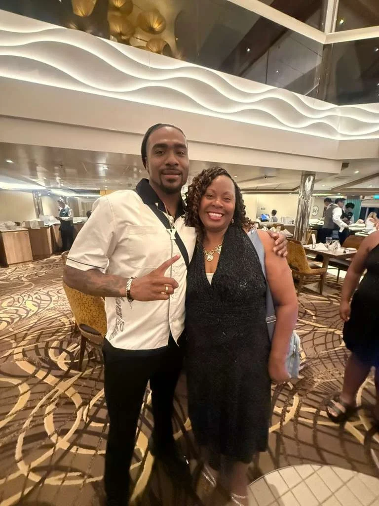 A man and woman smiling and posing together in a restaurant or banquet hall with elaborate decor.