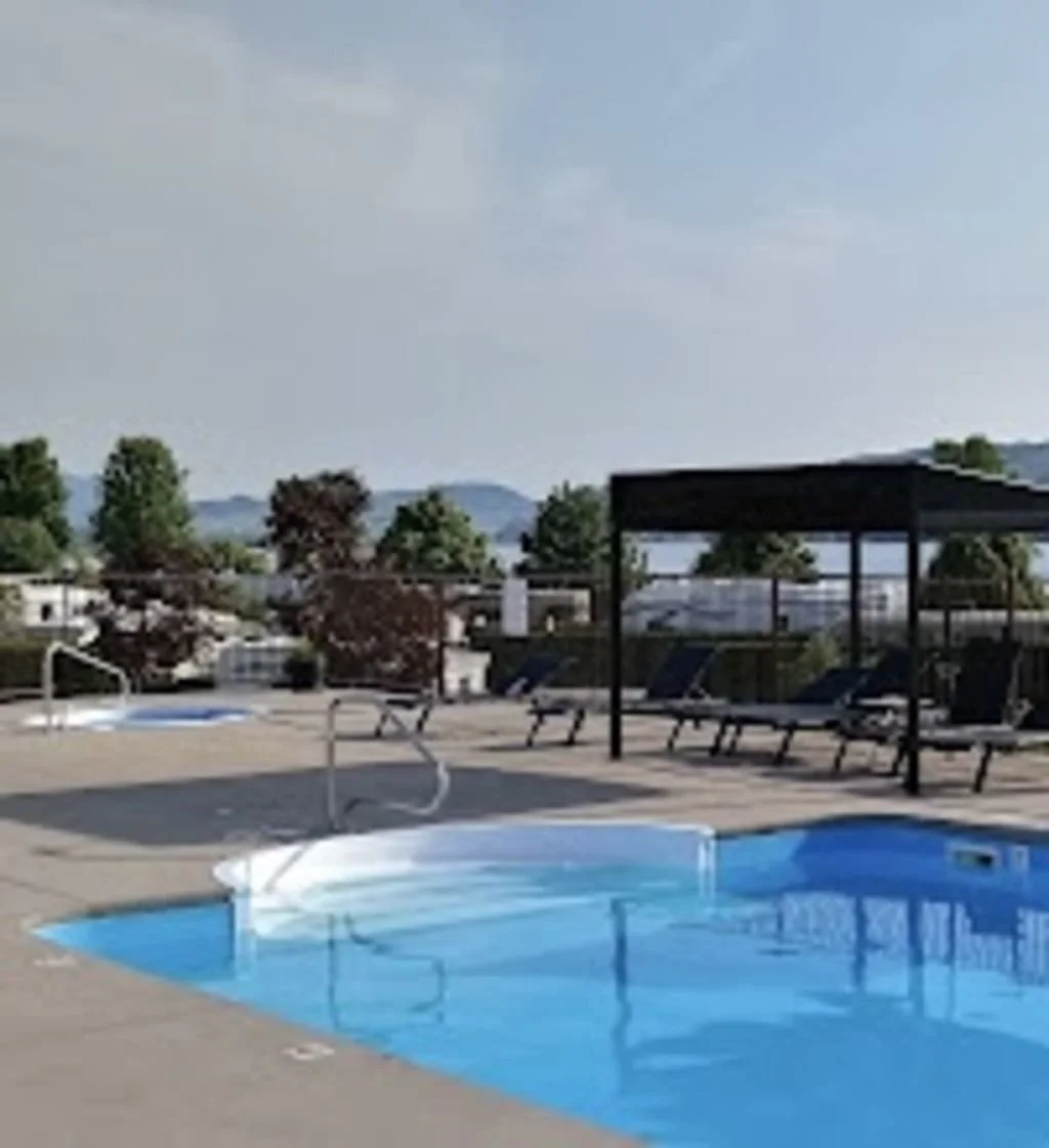 Swan Lake RV Resort swimming pool and hot tub area with some of the lounge chairs and one of the gazebos.