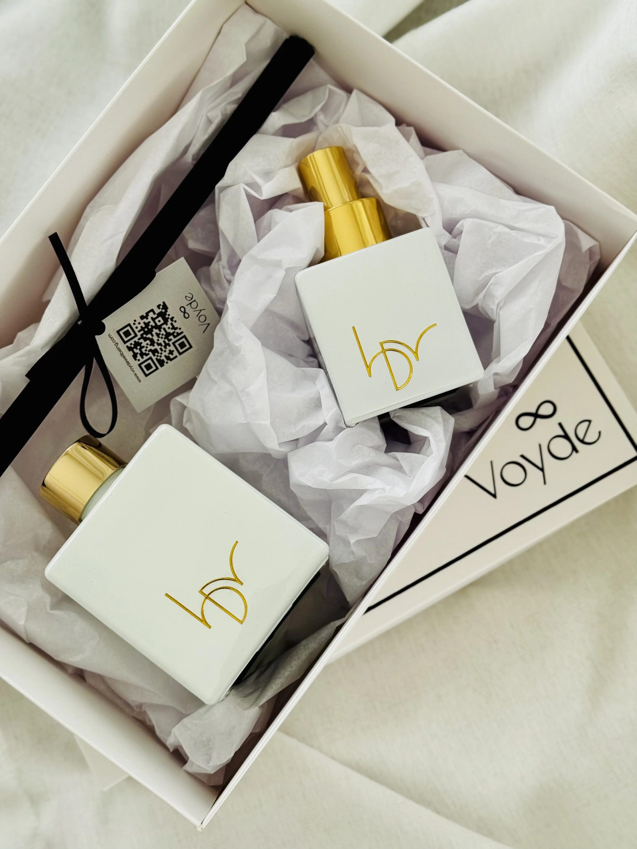 Signature Scenting for Business, gold and white bespoke fragrances bottles, surrounded by white tissue paper.