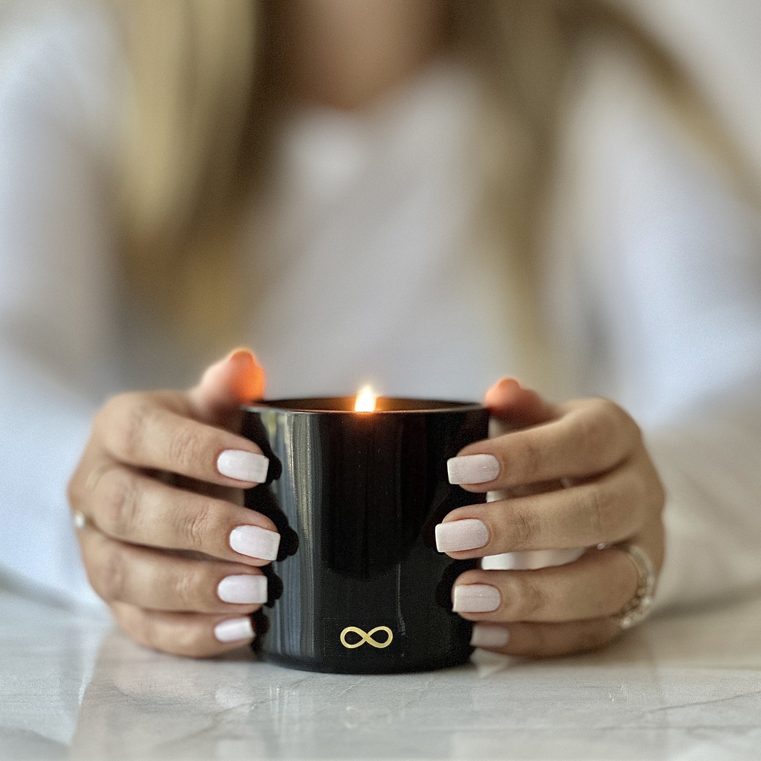 Beautiful woman holding a sophisticated botanical candle with natural ingredients