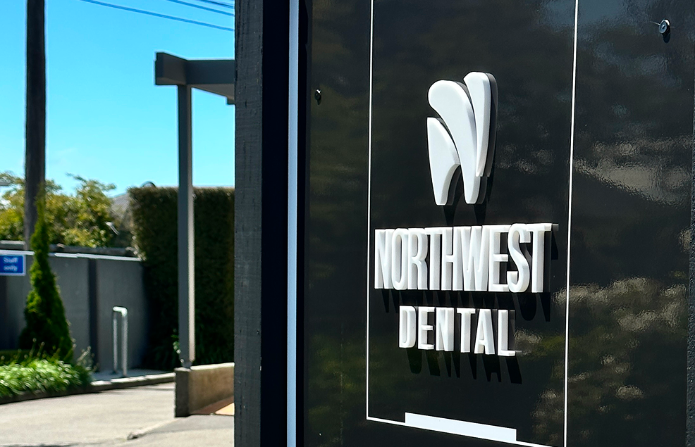 Sign for Northwest Dental with a logo on a black background.