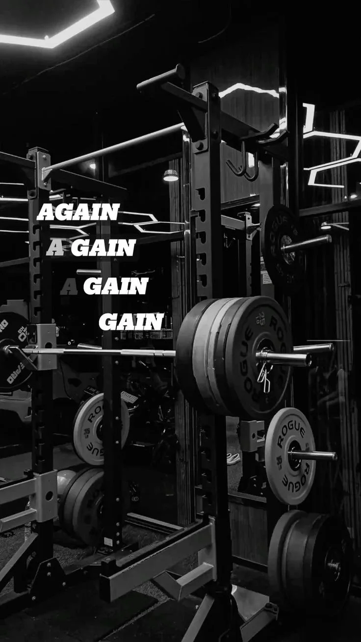 Gym weightlifting equipment with barbells and weight plates, illuminated by modern lighting, with motivational text 'AGAIN A GAIN' overlaid.