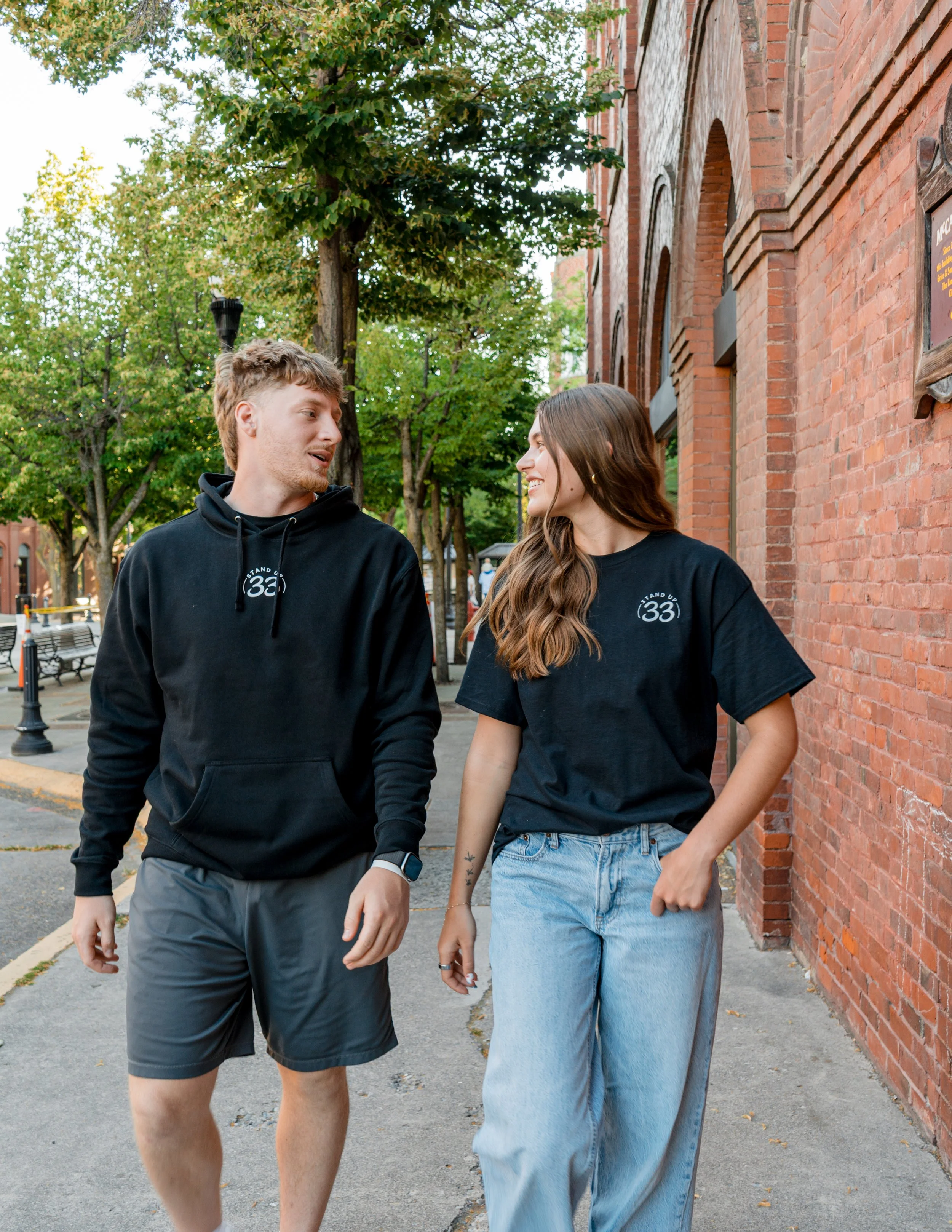 Two people wearing StandUp33 awareness apparel while walking and talking. 
