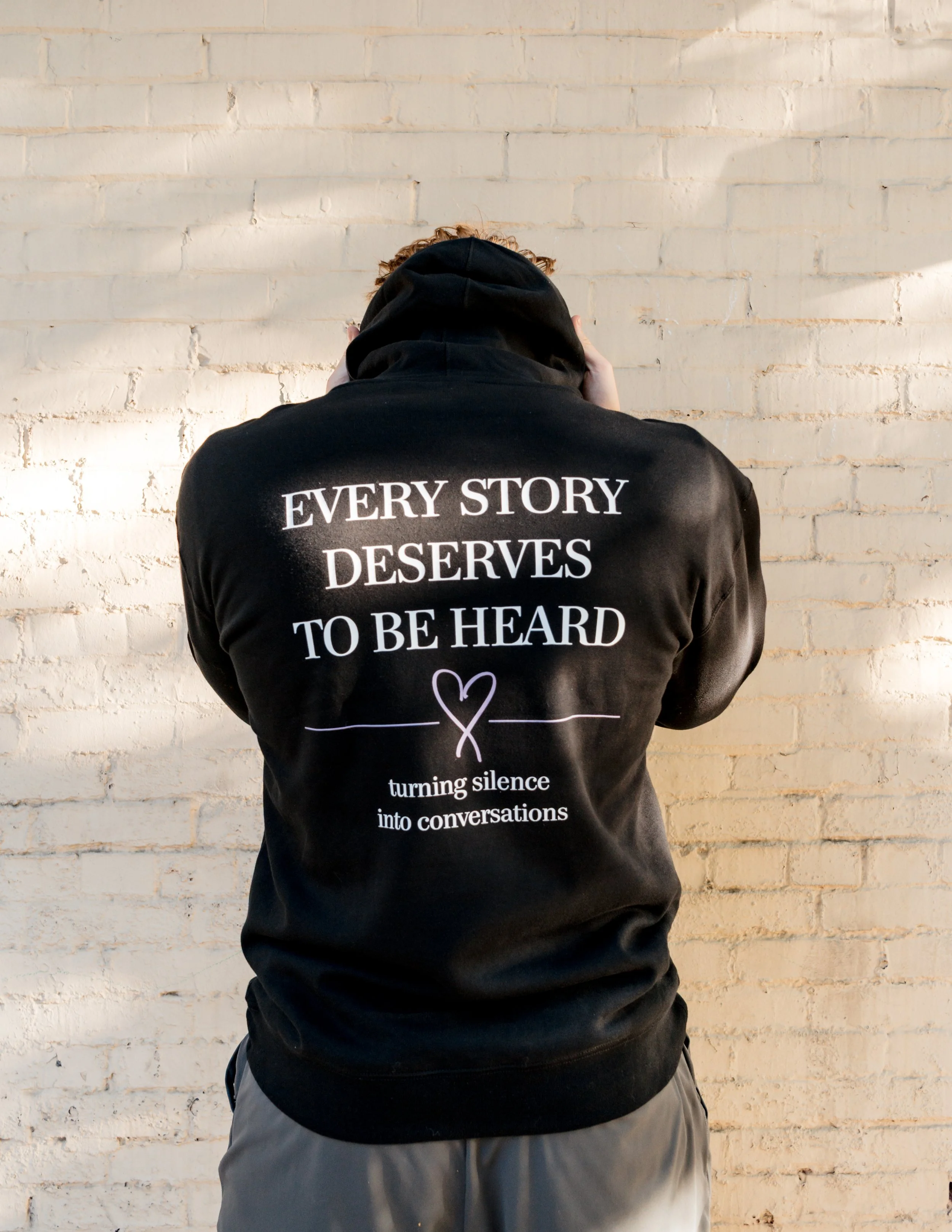 Back of a StandUp33 hoodie featuring the messages, "Every Story Deserves to Be Heard," and "Turning Silence into Conversations."