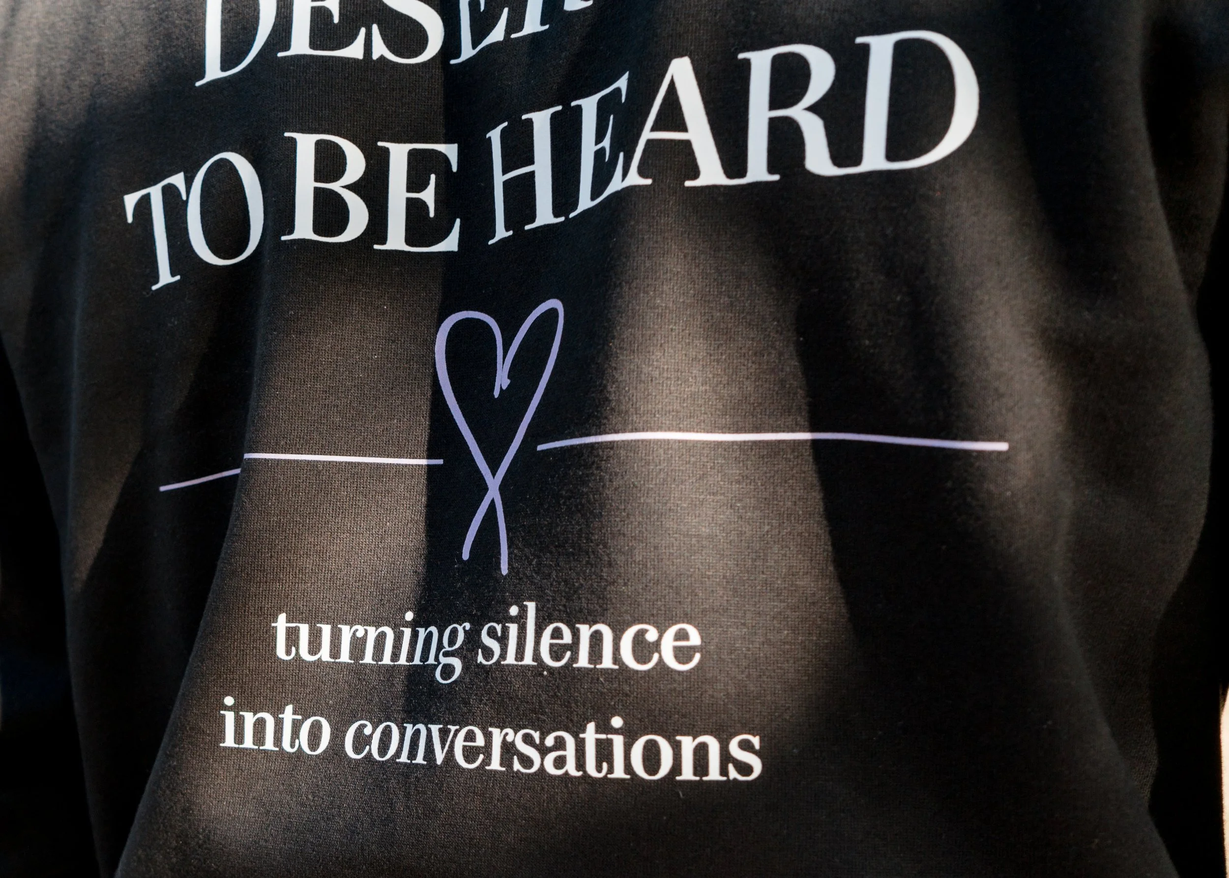 Close-up of the StandUp33 hoodie featuring the message, "Every Story Deserves to Be Heard."