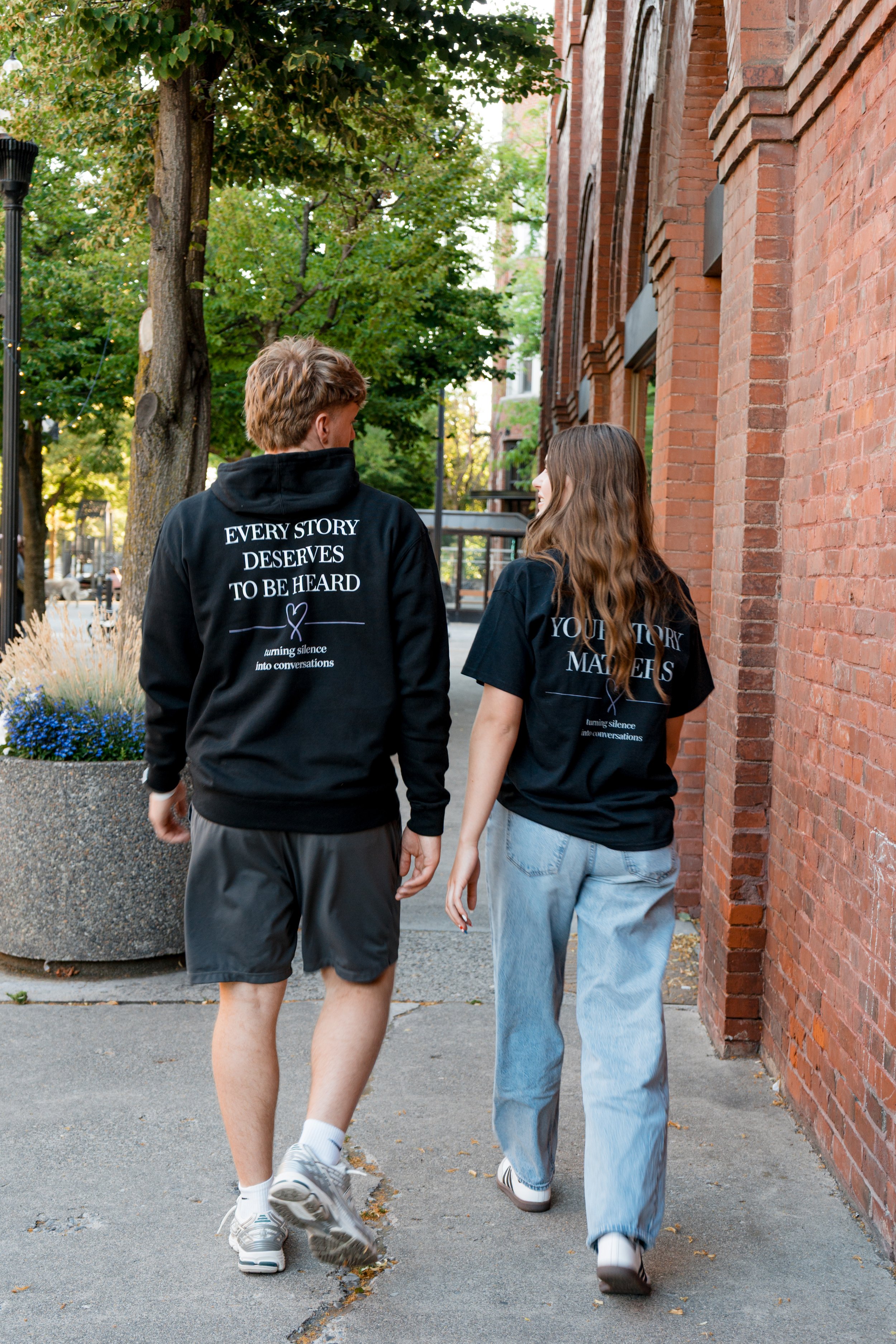 Two people wearing StandUp33 awareness apparel while walking together. 