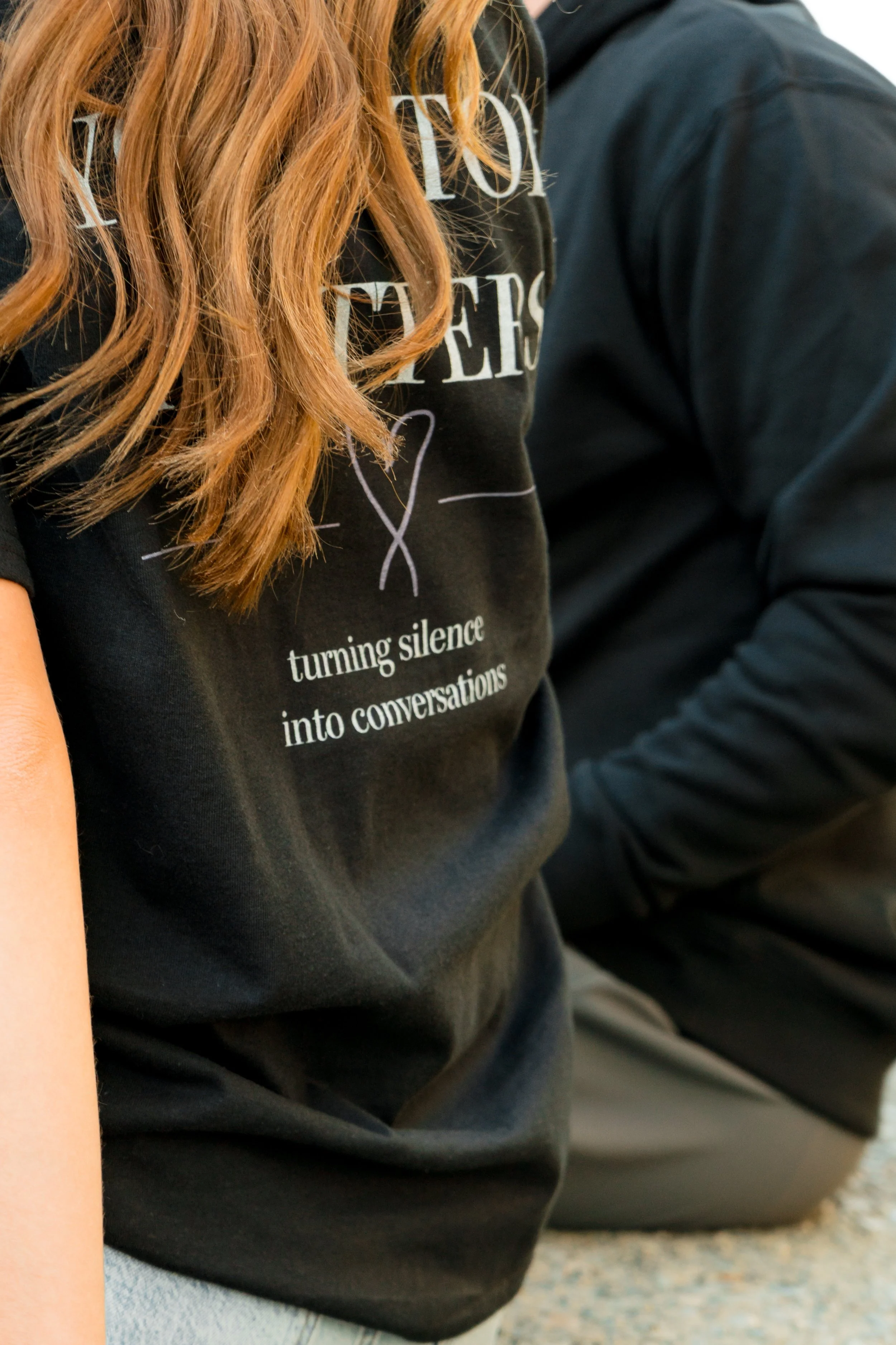 Close-up of two people wearing StandUp33 awareness apparel with inspirational messages.