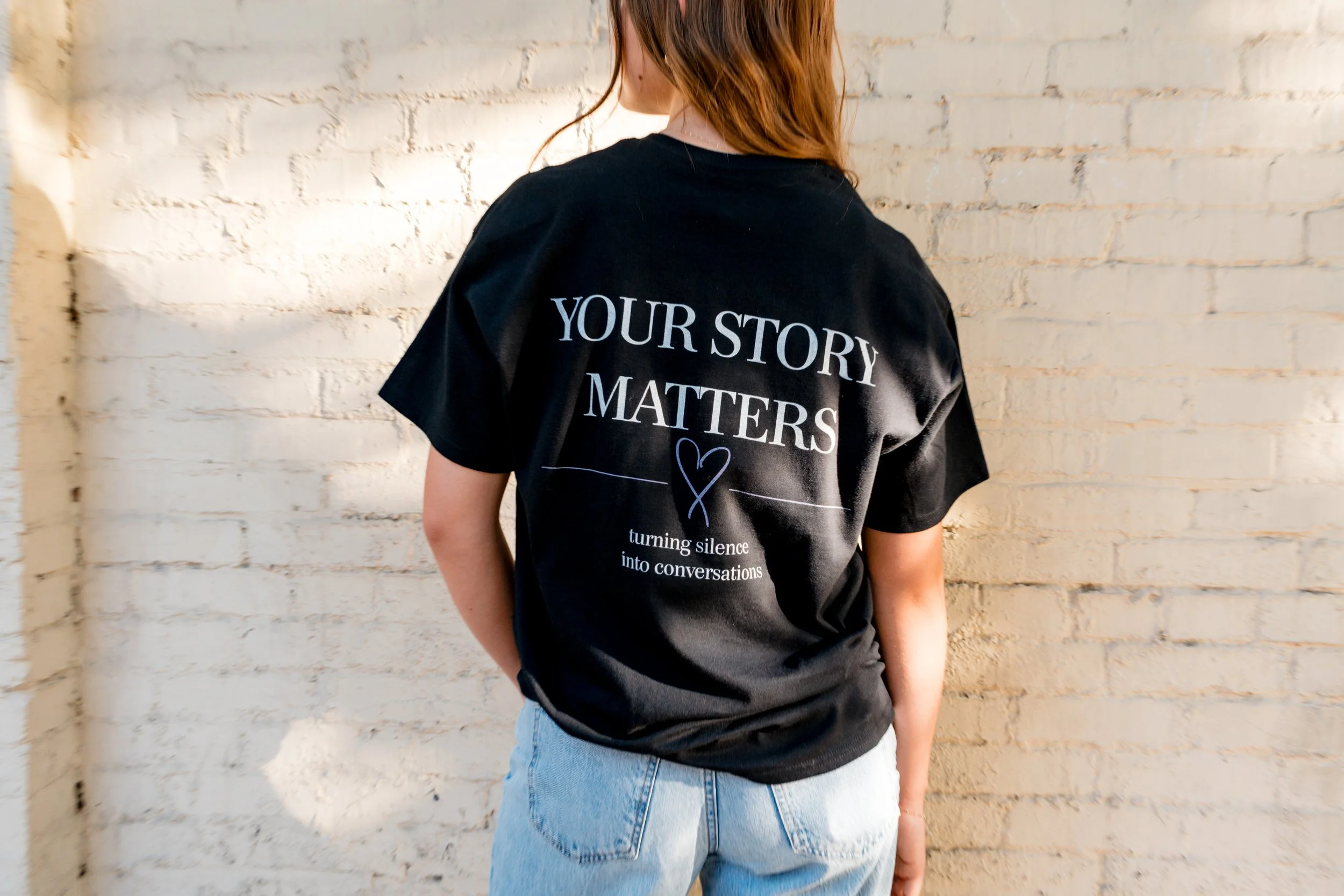 Back of a person wearing a StandUp33 T-shirt displaying the message, "Your Story Matters."