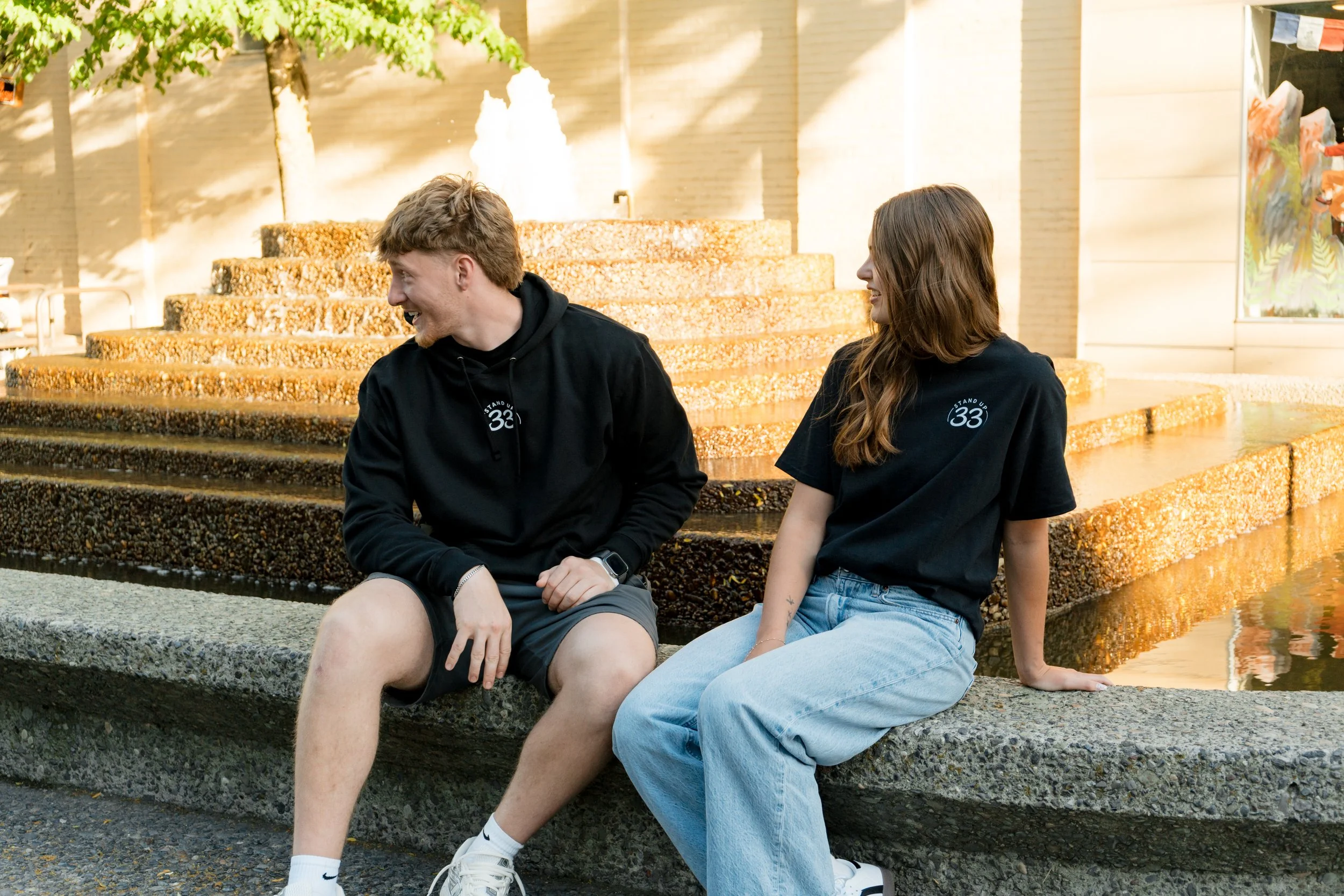 Two people wearing Standup33 awareness apparel sitting together smiling. 