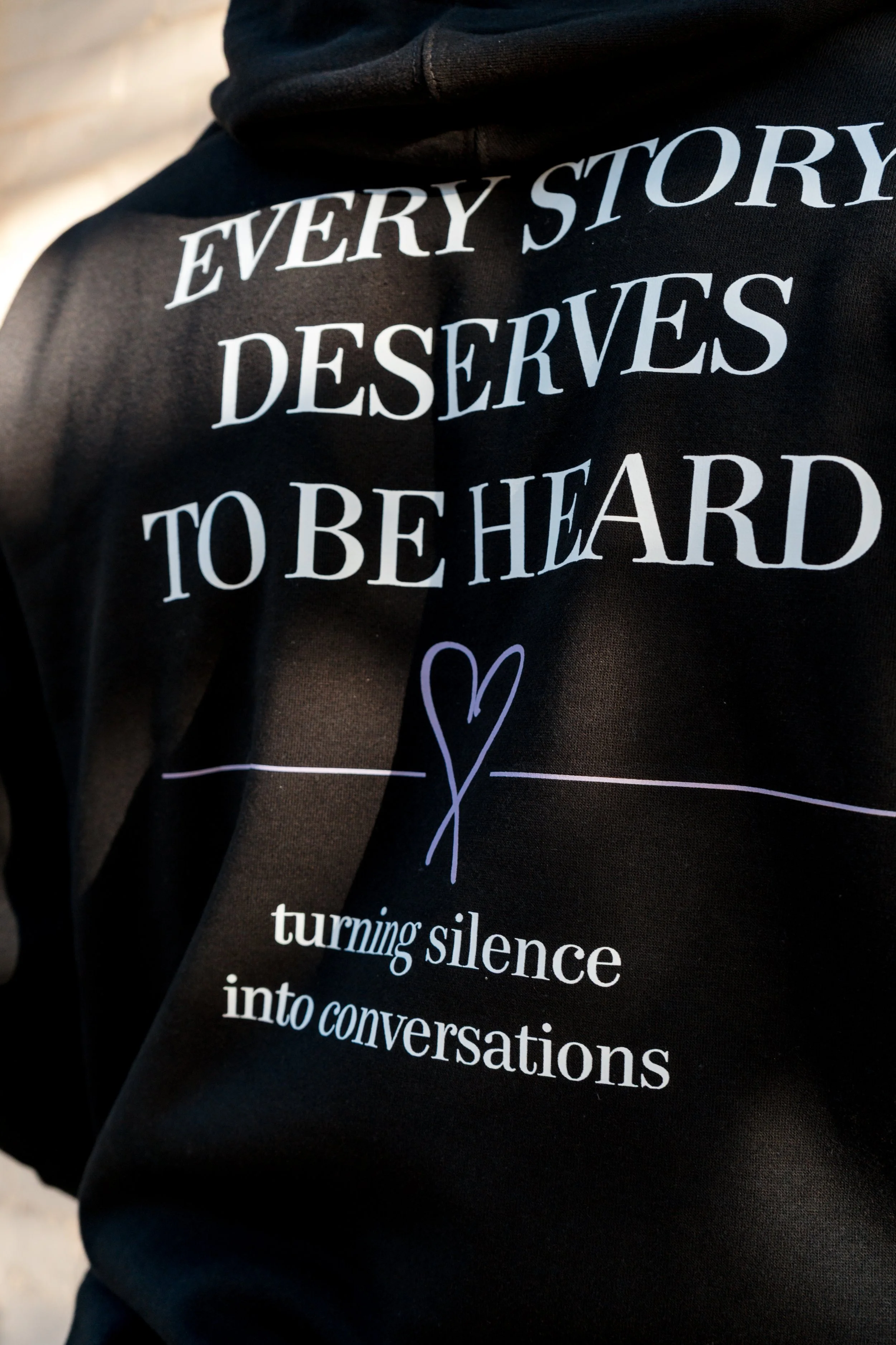 Close-up of the StandUp33 hoodie displaying the message, "Every Story Deserves to Be Heard."