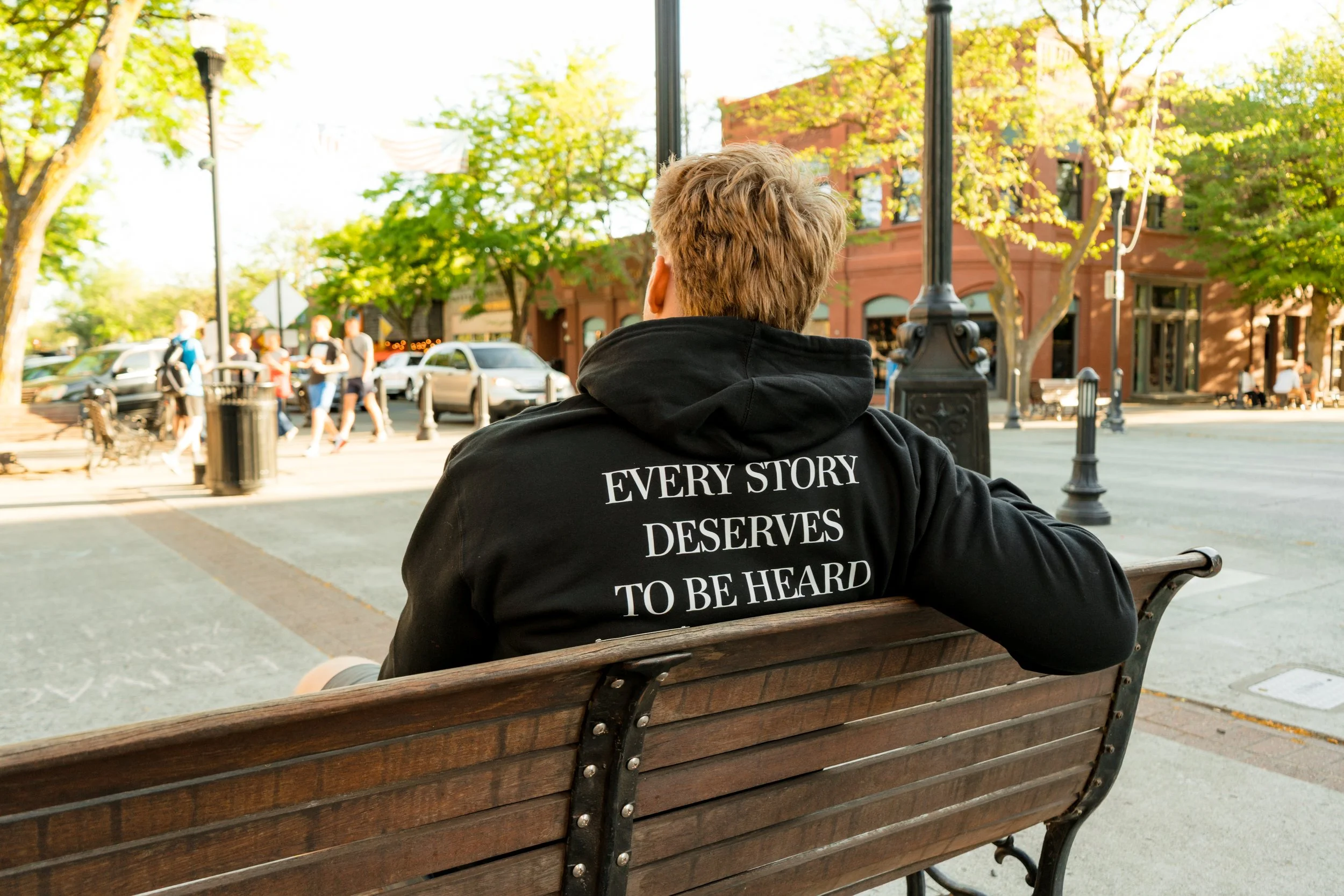 Person wearing a StandUp33 hoodie with the message, "Every Story Deserves to Be Heard."