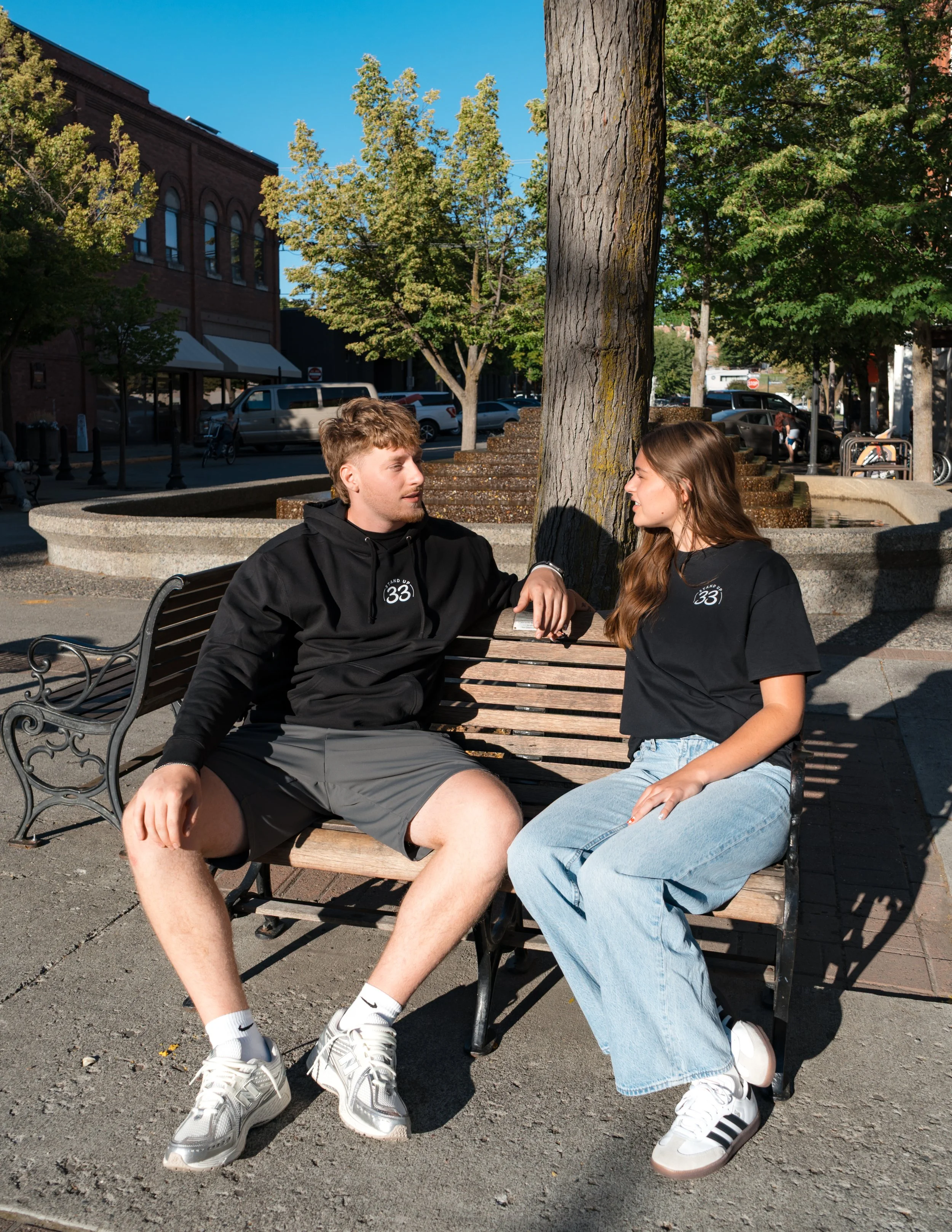 Two people wearing StandUp33 awareness apparel while sitting together outdoors.