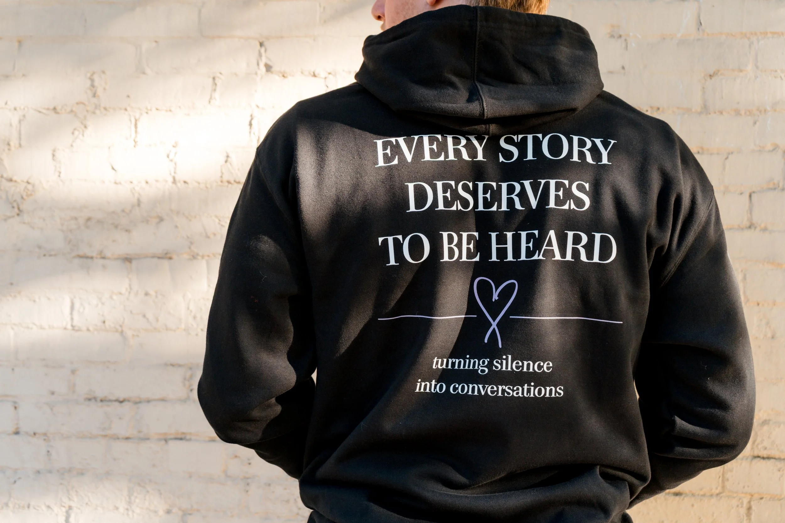Back of StandUp33 hoodie featuring the message, "Every Story Deserves to Be Heard."