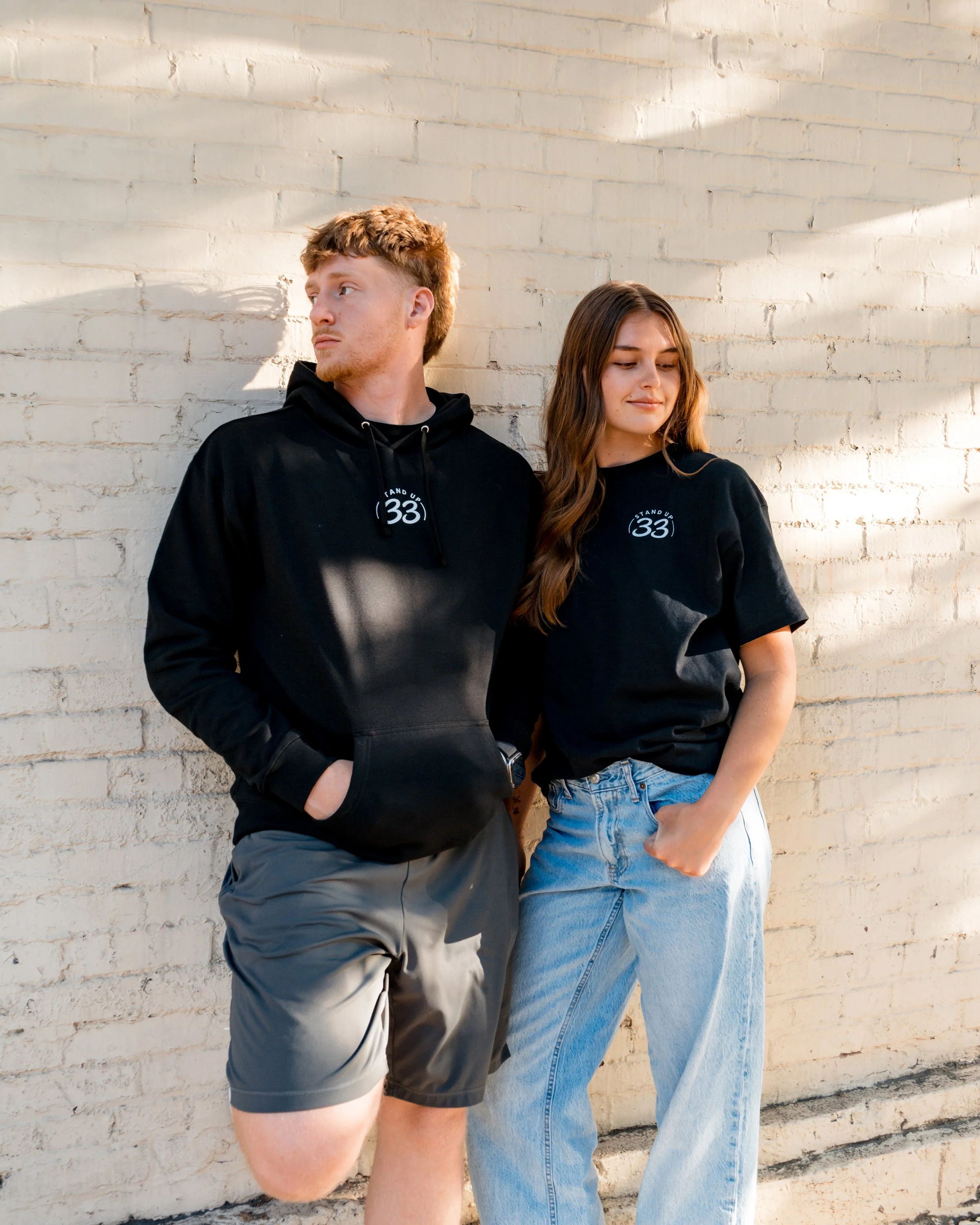 Two people wearing StandUp33 awareness hoodies that promote awareness. 