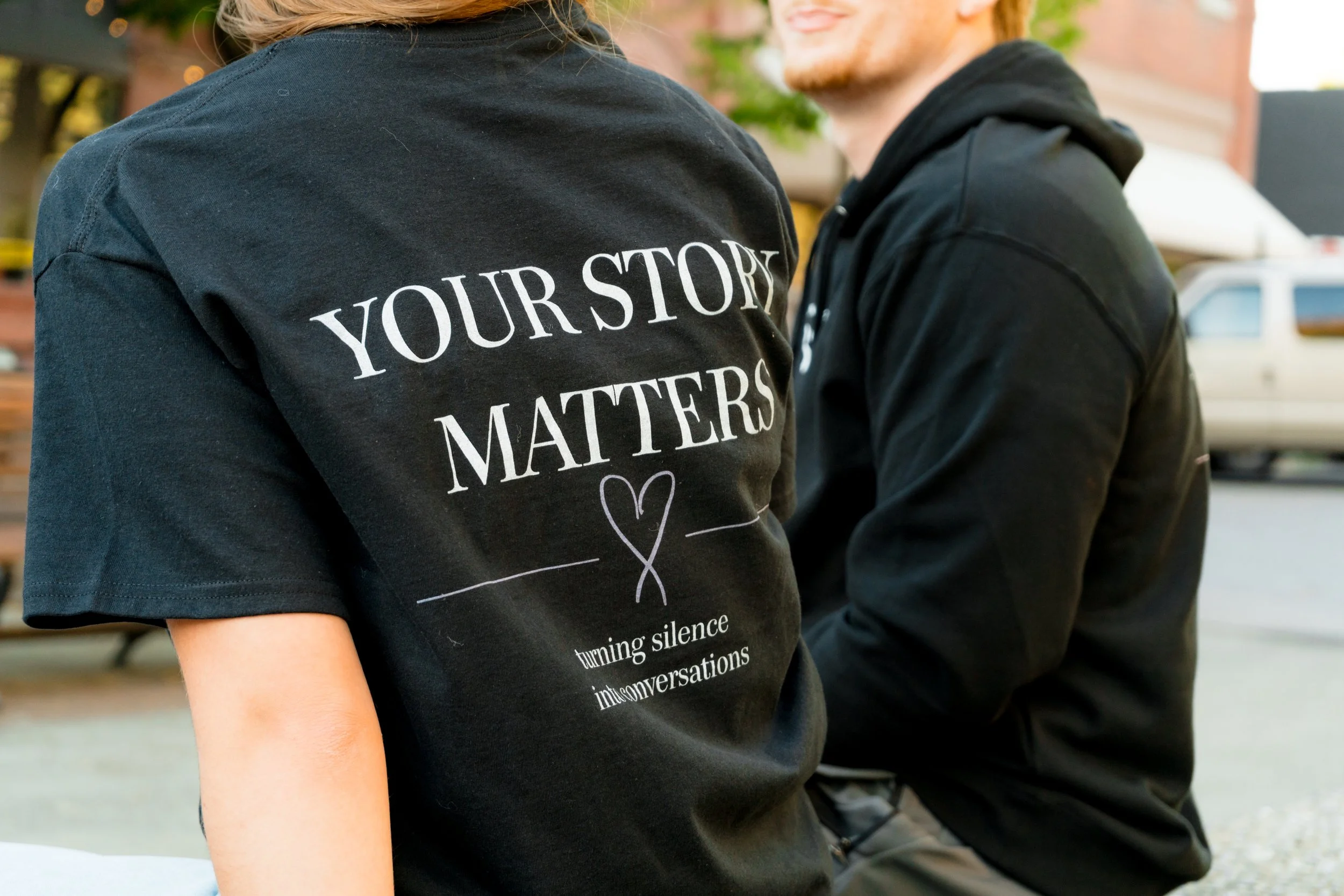 Two people wearing StandUp33 awareness apparel displaying inspirational messages.