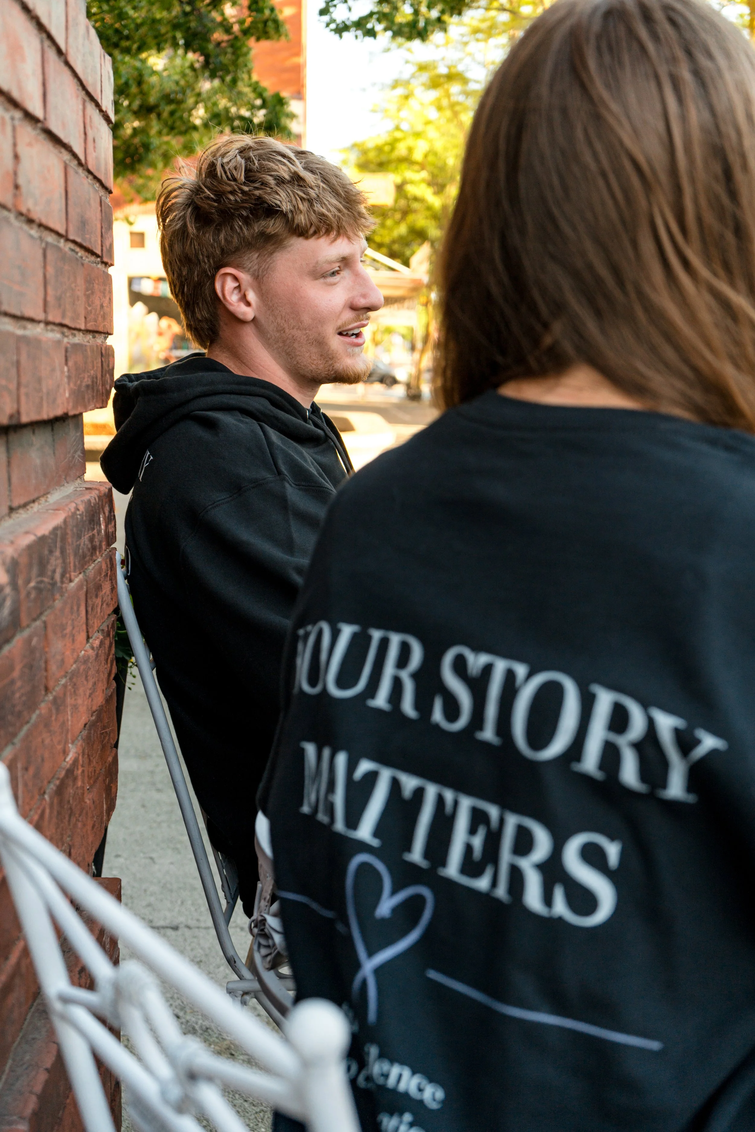 Two people wearing StandUp33 awareness apparel while talking outdoors.