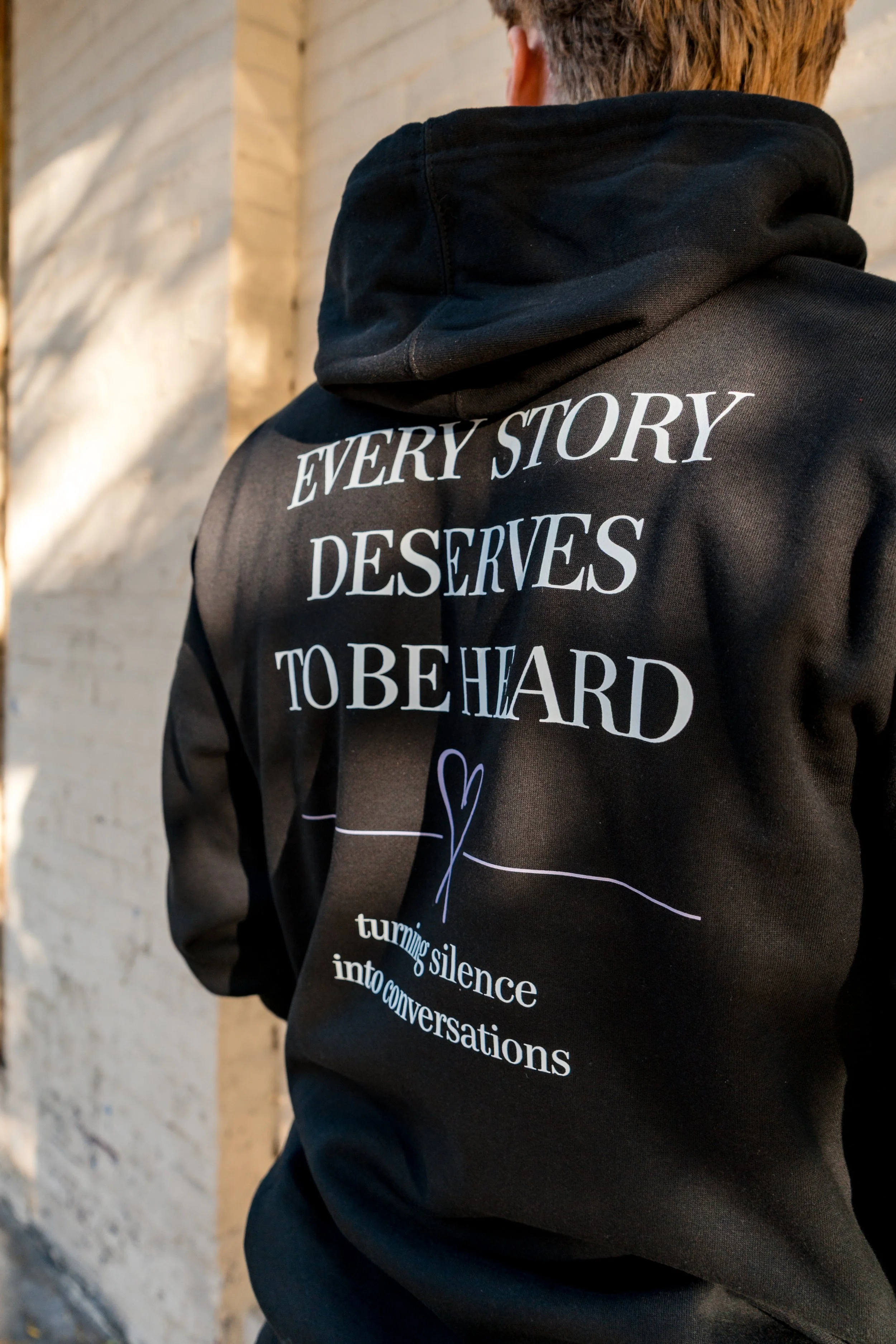 Back of StandUp33 hoodie displaying the message, "Every Story Deserves to Be Heard."