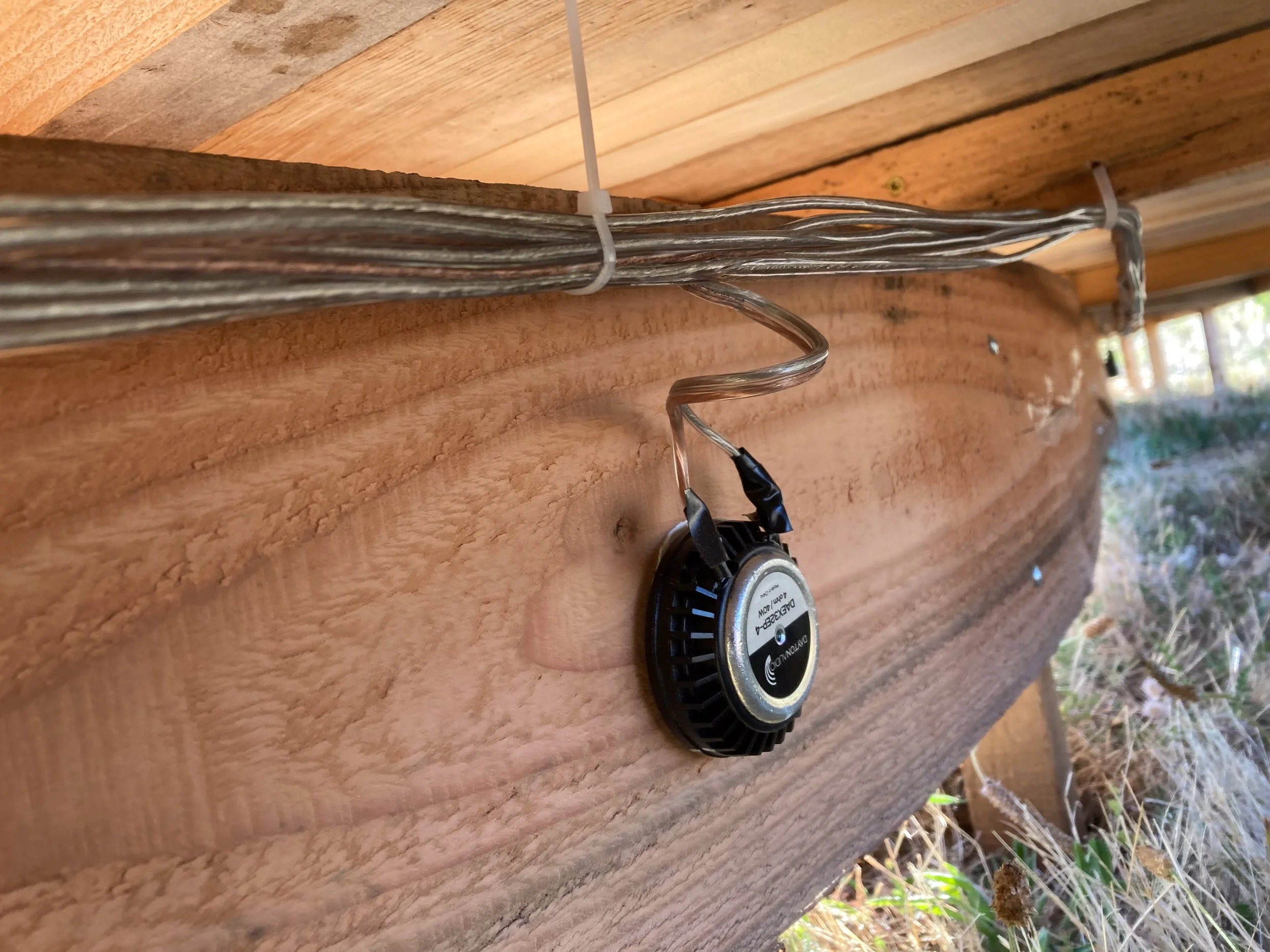 A hidden tactile transducer speaker is wired to the underside of a wooden bench, in a piece by sculptor Philip Krohn with a sound installation by Seth Nehil.