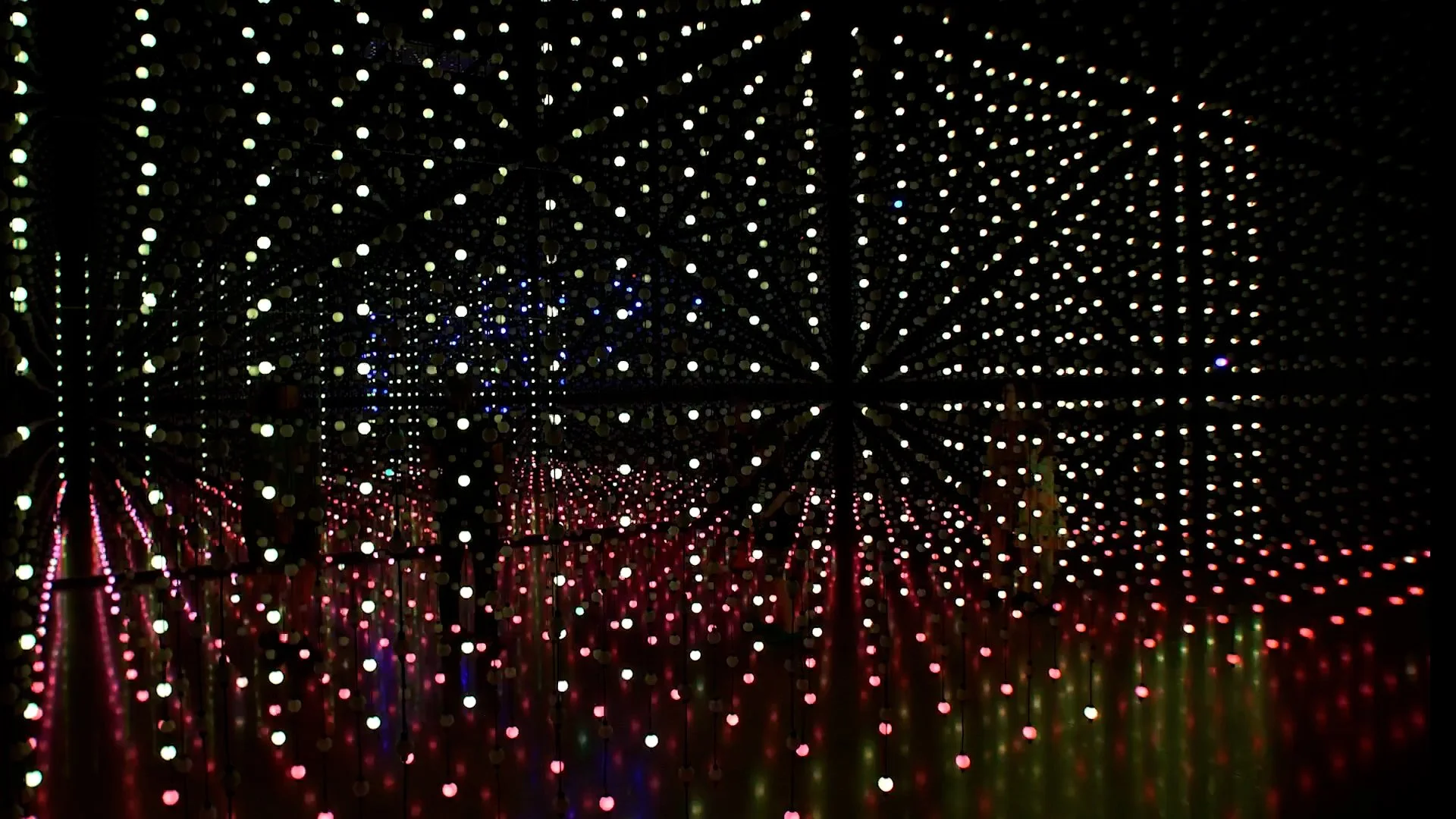 Abstract geometic shapes are formed by LED strands in a large, dark space  Unknown Atmospheres by Seth Nehil and Parallel Studio at Hopscotch Gallery