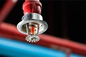 Close-up of a metallic sprinkler head spraying water.