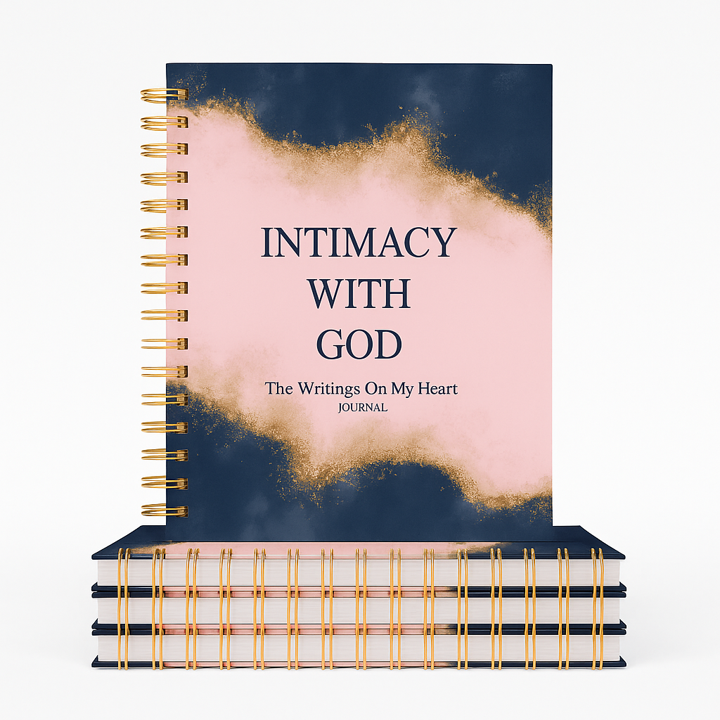 A pink and navy blue spiral-bound journal with gold accents, titled 'Intimacy with God: The Writings On My Heart,' placed on top of two larger dark-colored notebooks.