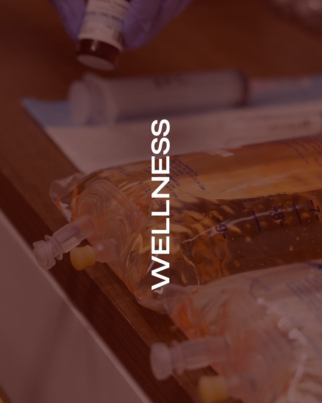 Medical IV bags and syringes on a wooden surface