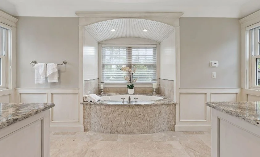 Bathrooms with bathtub, granite countertops, and large windows.