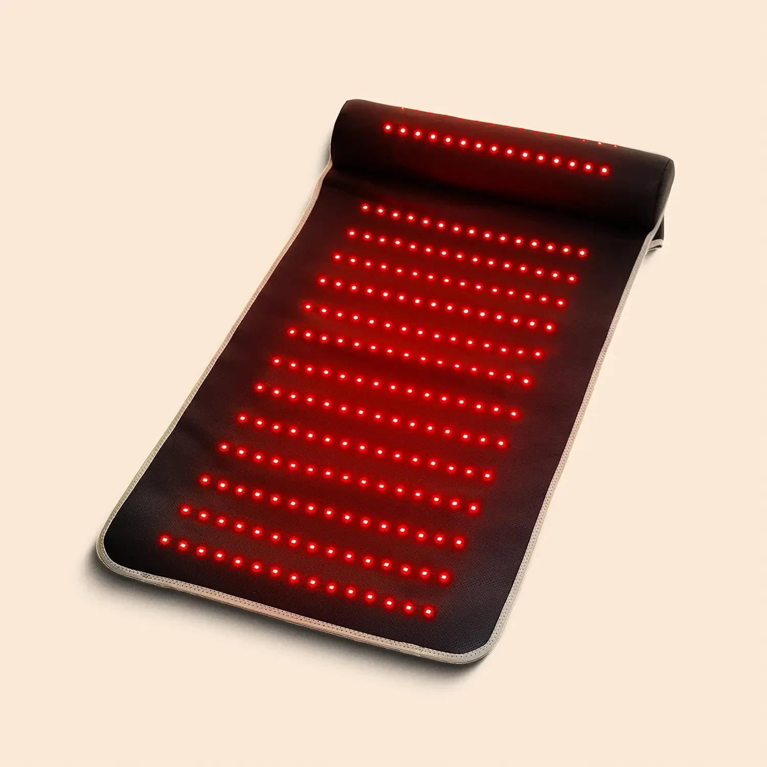A black acupuncture mat with red LED lights, rolled at the top for support.