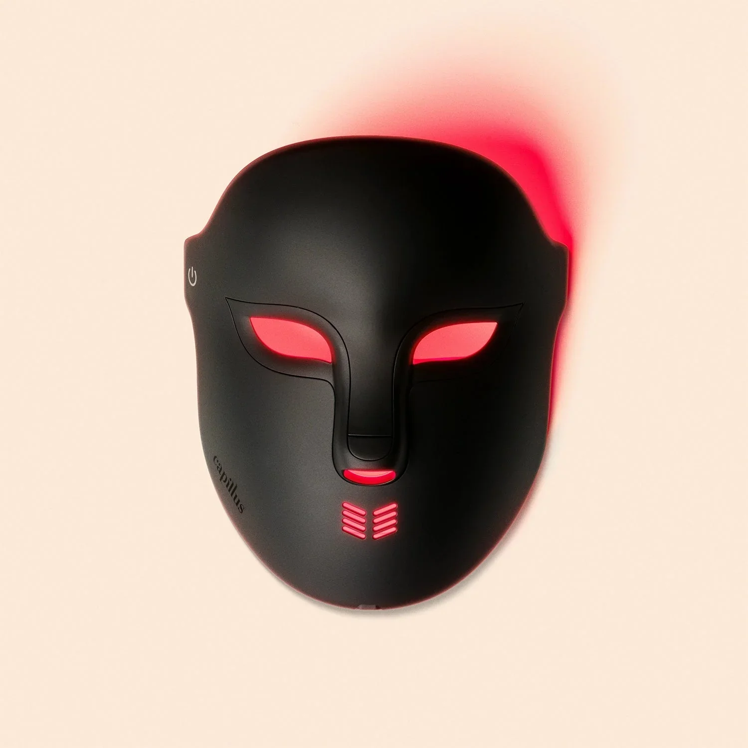 A black mask-shaped electronic device with red-lit eye holes and vents, placed on a plain light background.