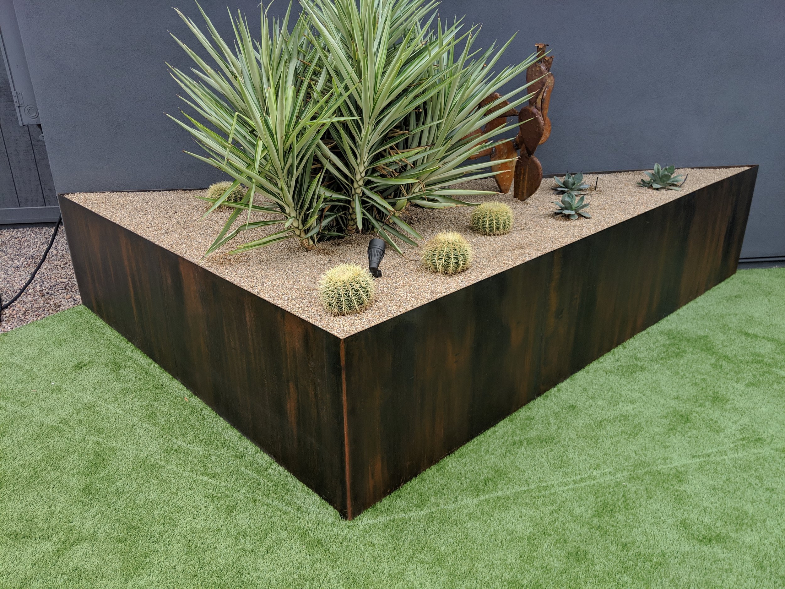 Custom triangular Corten steel planter with desert plants, fabricated by Full Spectrum Artworks Phoenix